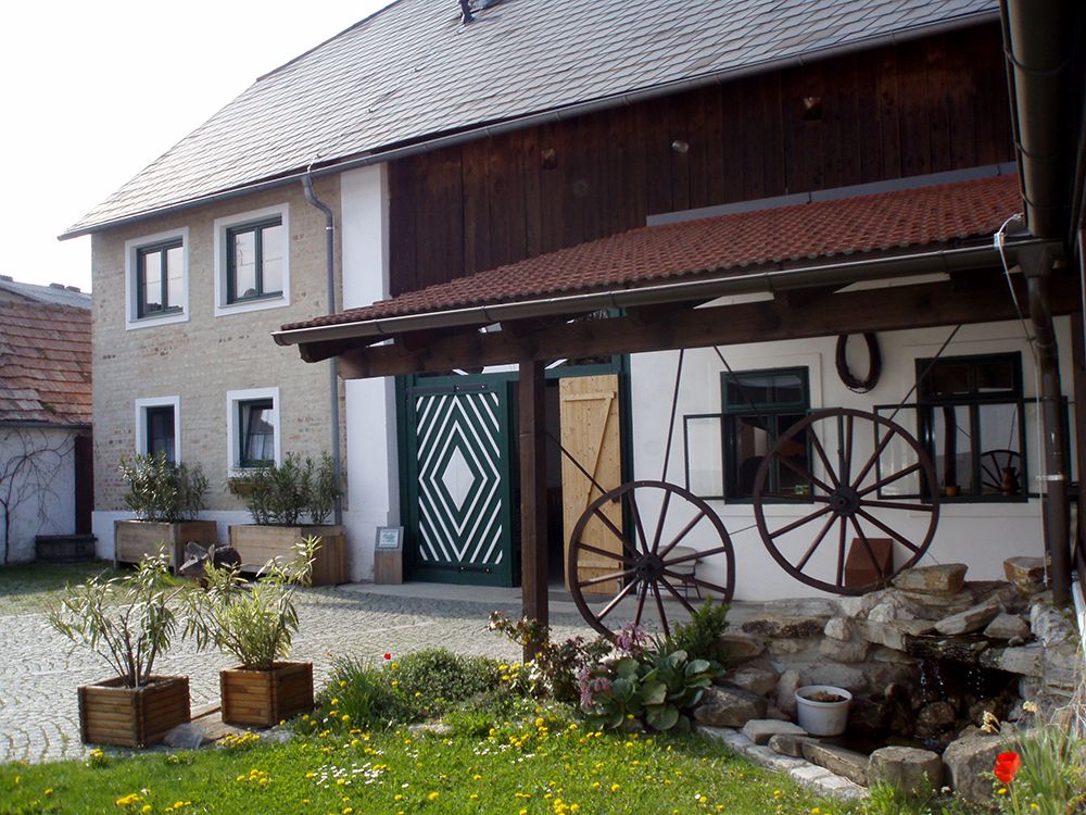 Traditional building with wooden roof and decorative wagon wheels in the courtyard.