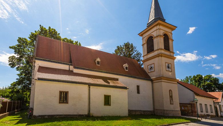 Church with tower and red roof in Winzendorf in the sunshine.