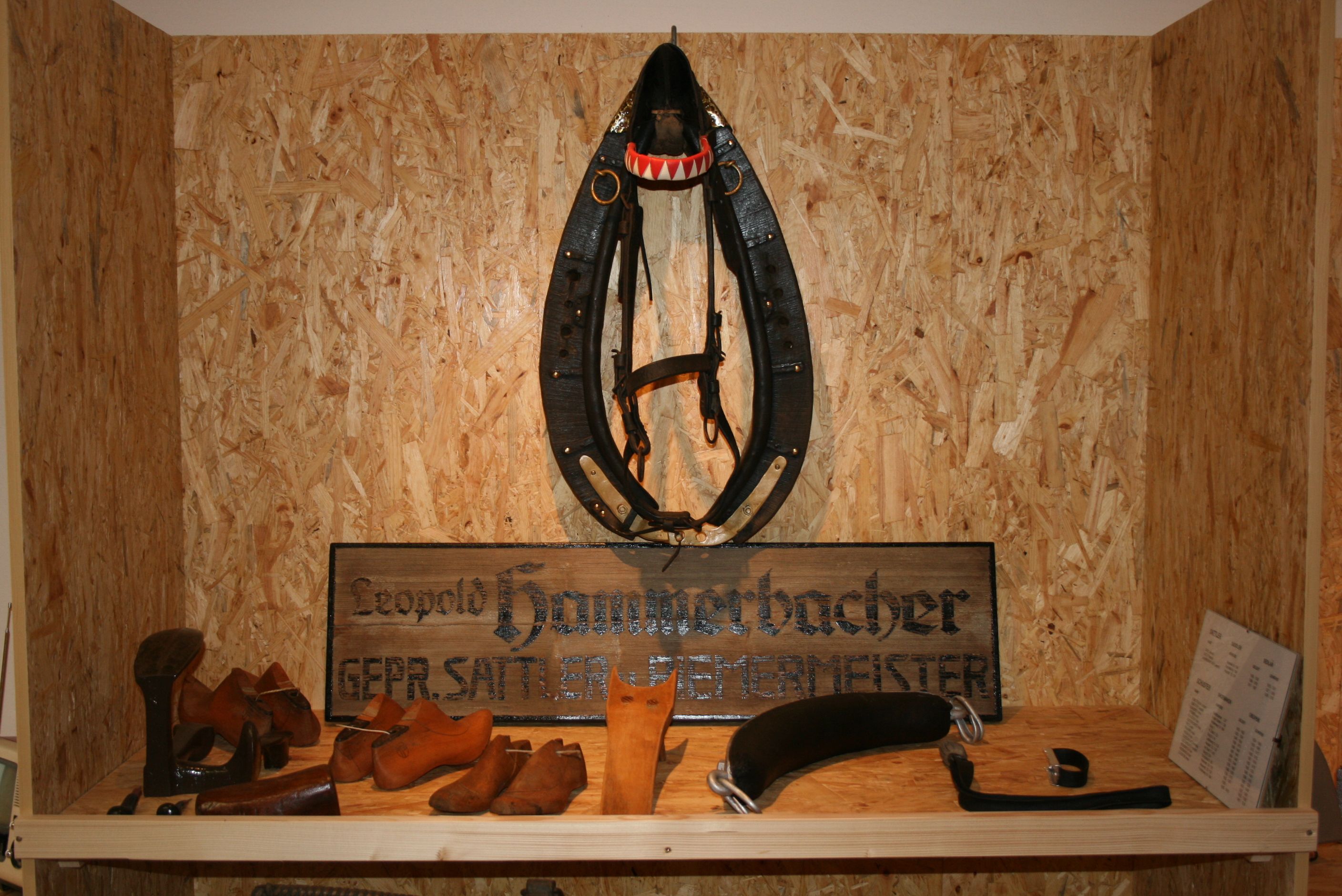 Exhibit in a museum with saddler's tools and a horse harness.