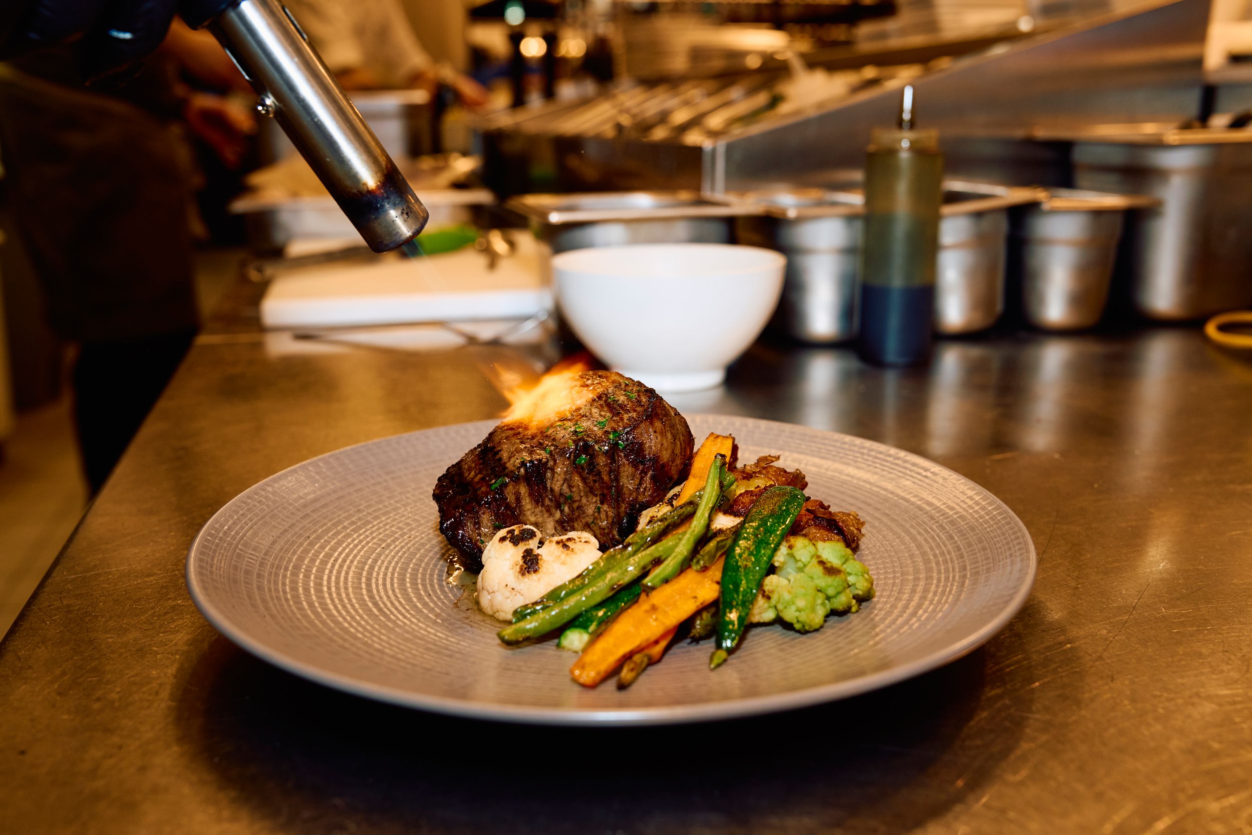 Wolfgang Puck Kitchen + Bar, meat is flambéed on the plate