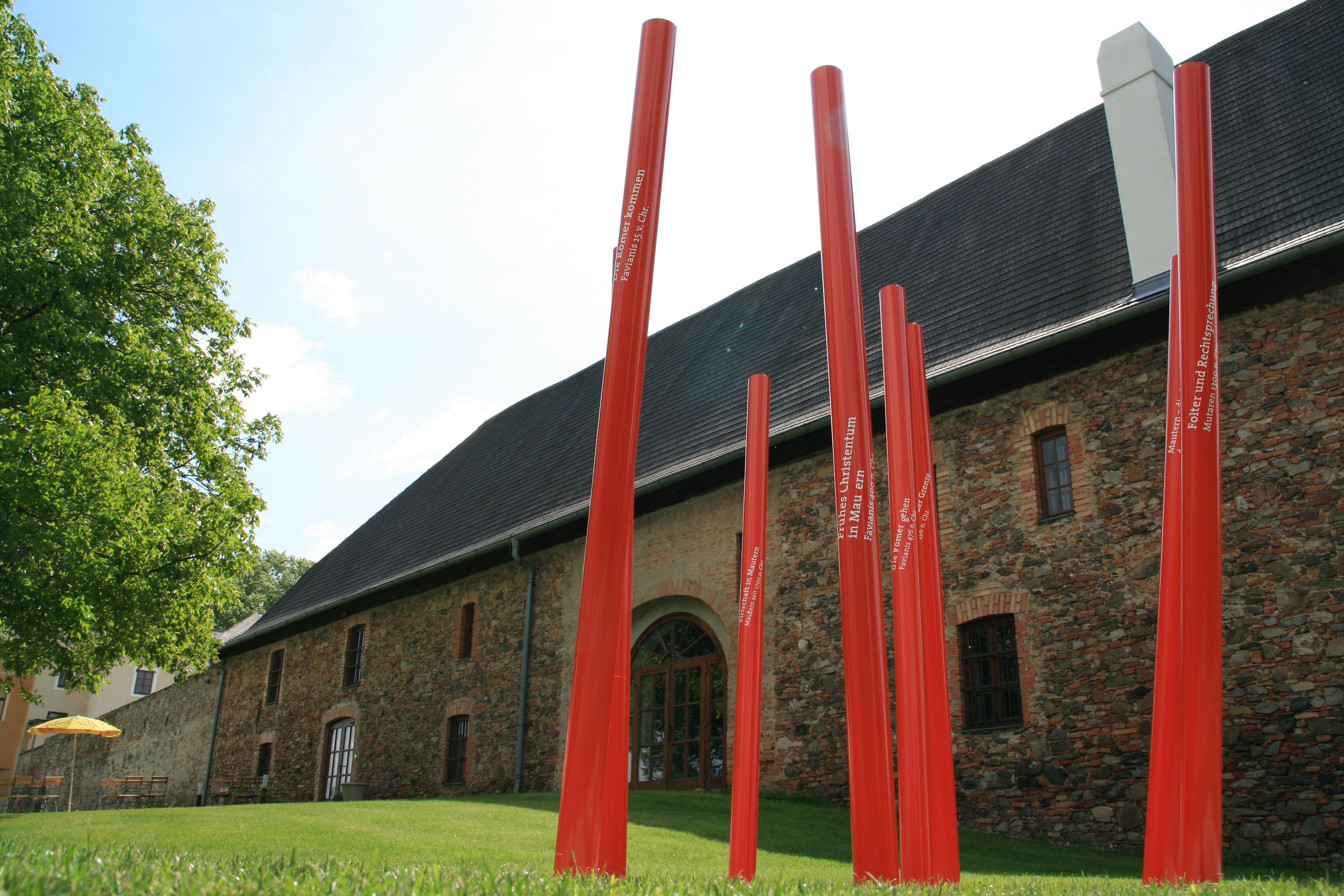Red poles in front of a historic building in Mautern.
