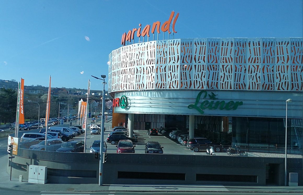 Mariandl shopping center in Krems with Leiner logo and parking spaces in front of it.