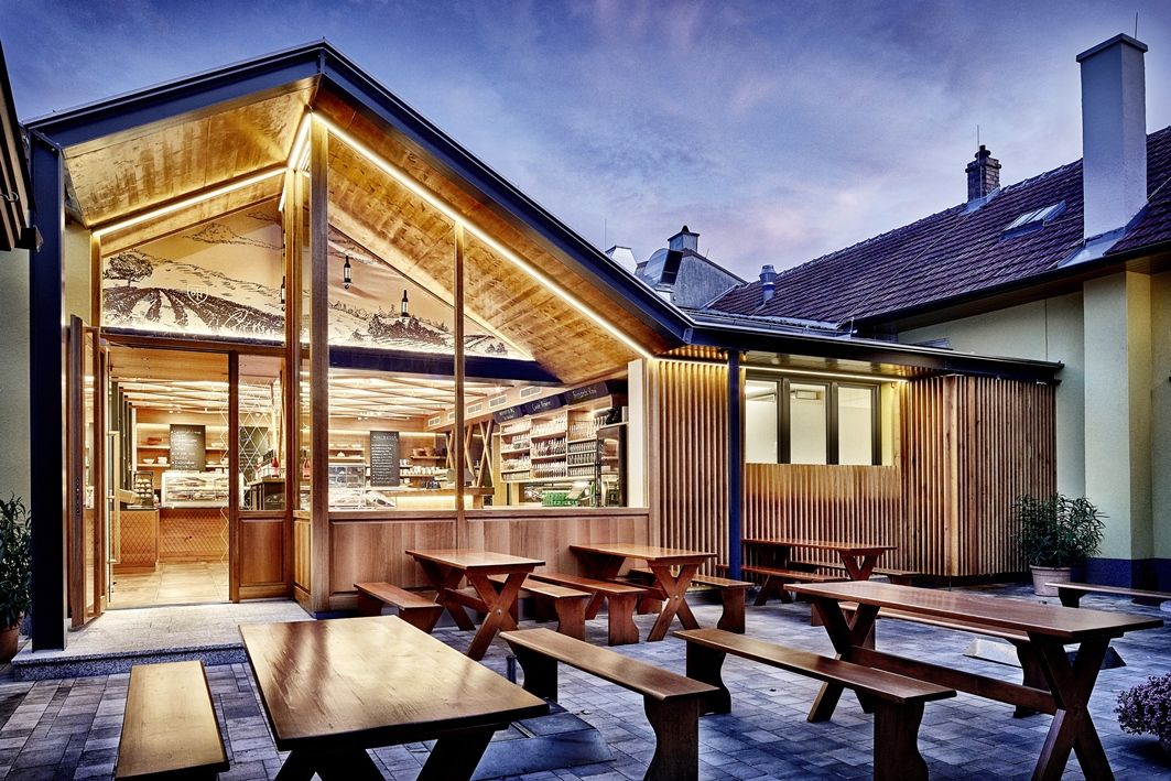 Modern winery with wooden elements and outdoor area at dusk.