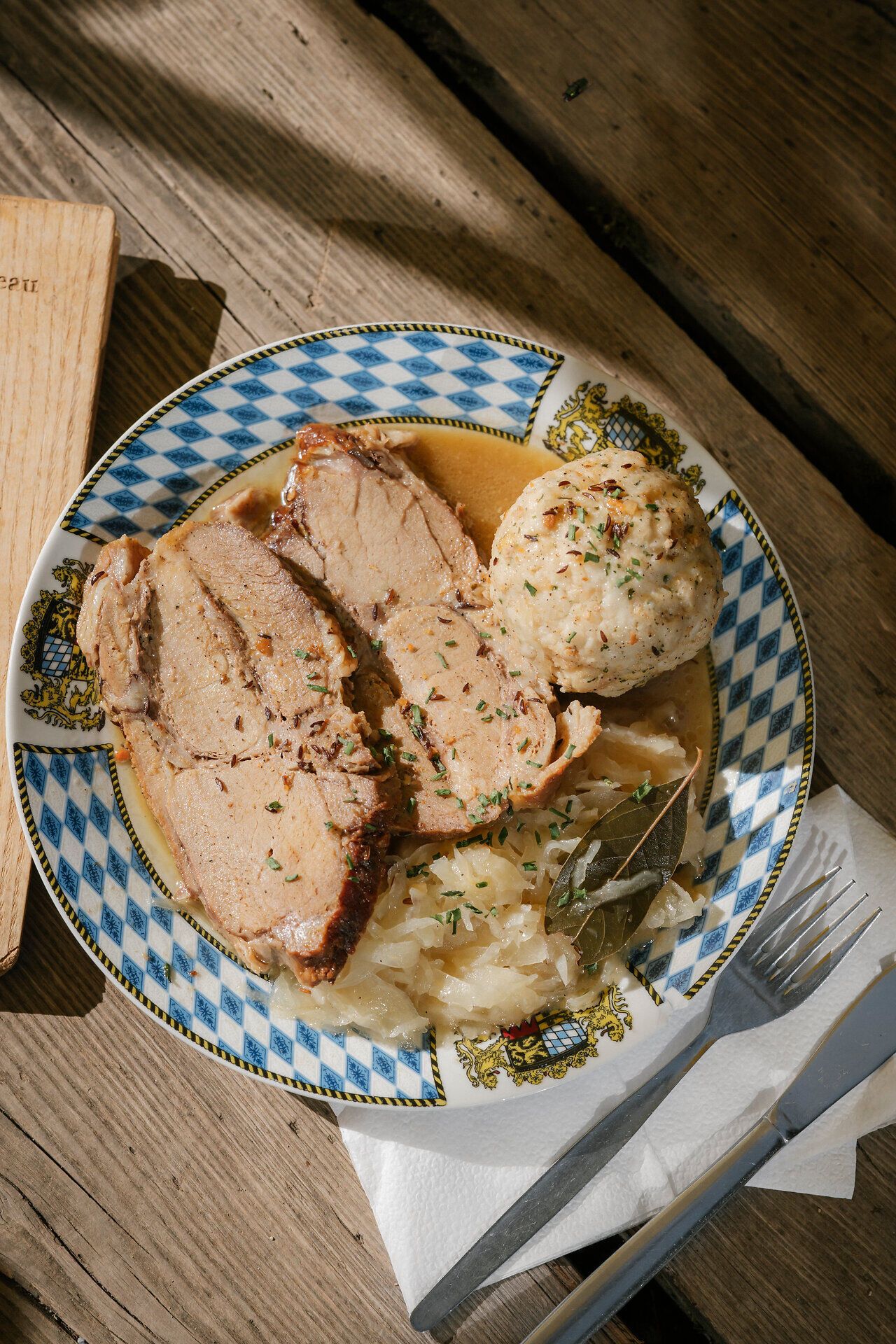 Roast pork with sauerkraut and bread dumplings on a plate at the Edelweißhütte on Schneeberg