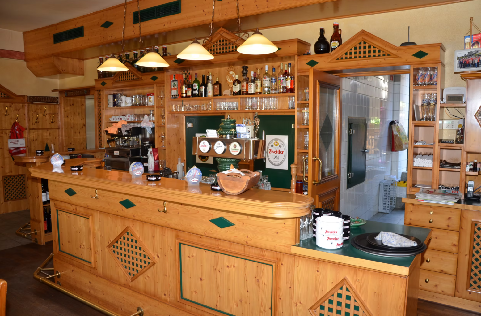 Interior view of a rustic bar with wooden furniture and drinks.