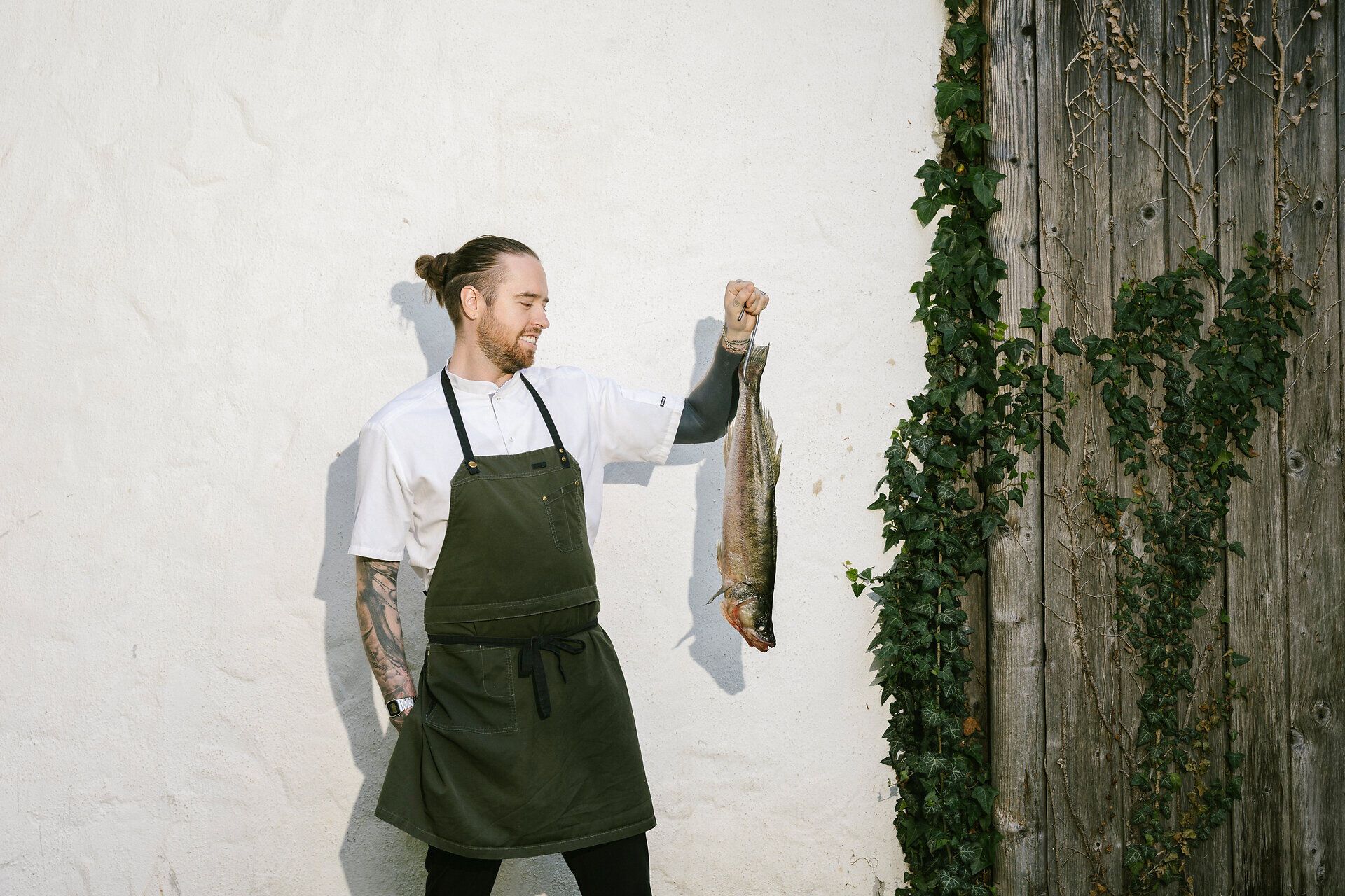 A chef is holding a fish in his hand