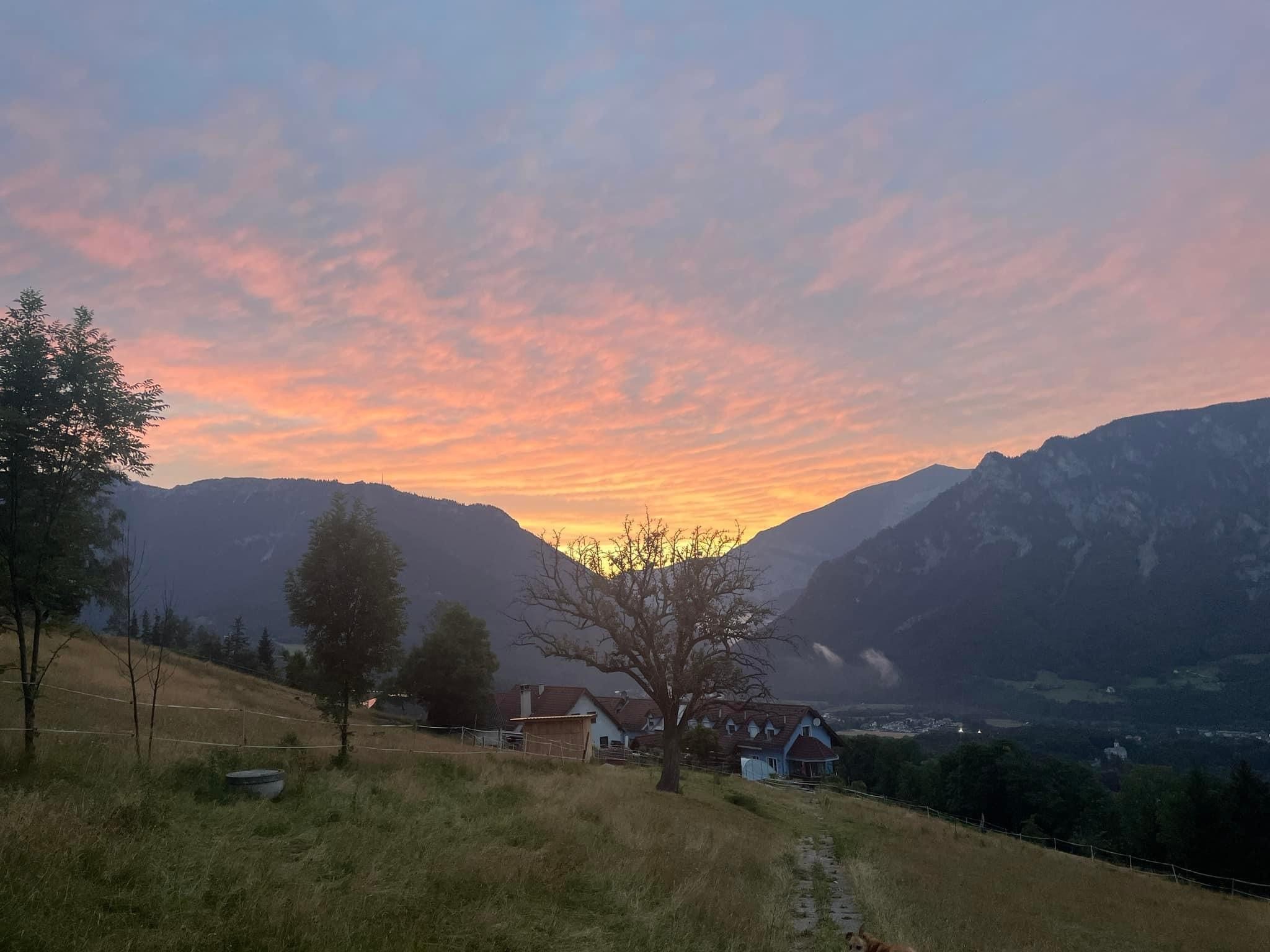 View of a house in a mountain landscape at sunset.