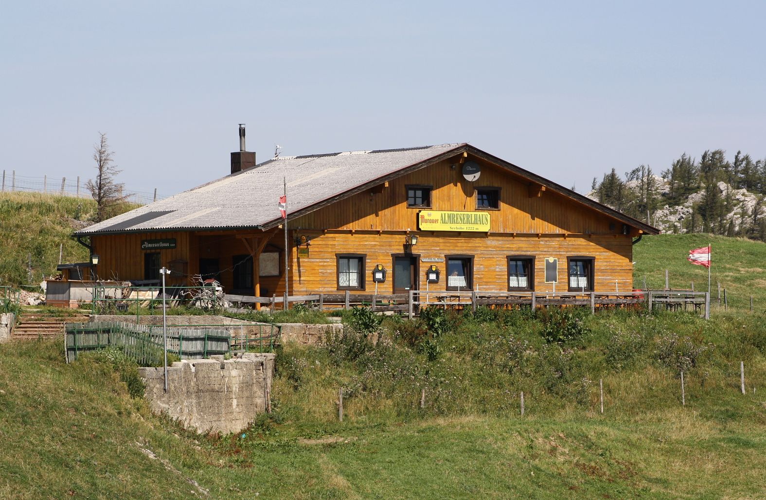 A traditional wooden building in an alpine landscape with the inscription 'Almreserhaus'.