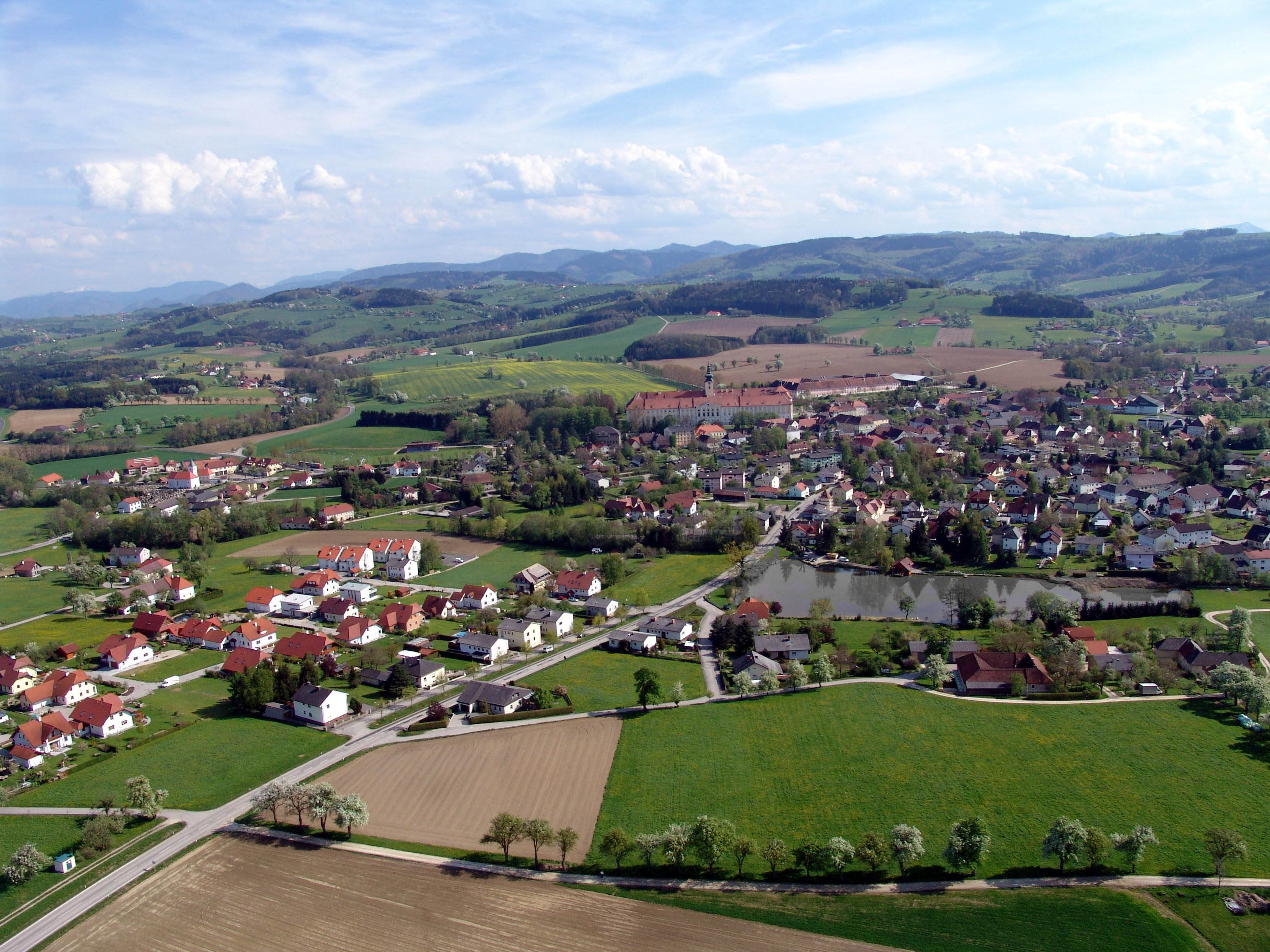 Aerial view of Seitenstetten with fields, houses and hills in the background.