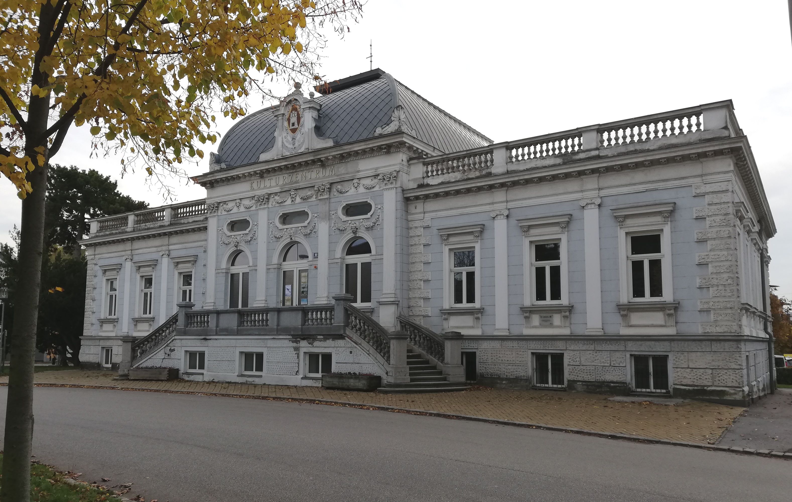 Exterior view of the Korneuburg City Museum in fall with yellow leaves in the foreground.