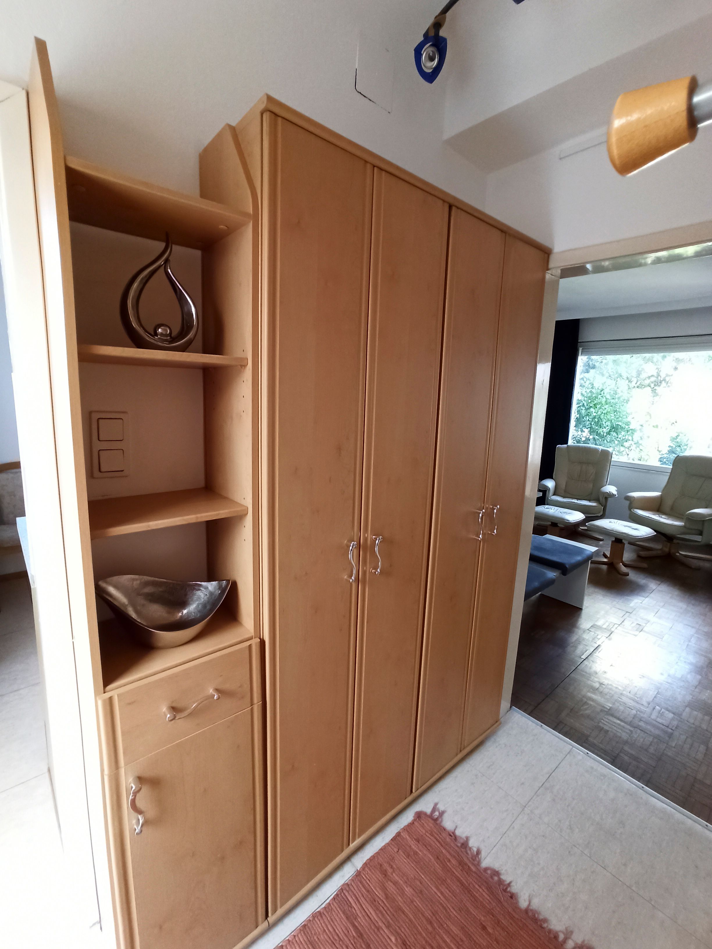 Wooden cupboard with shelves and drawers in one room.