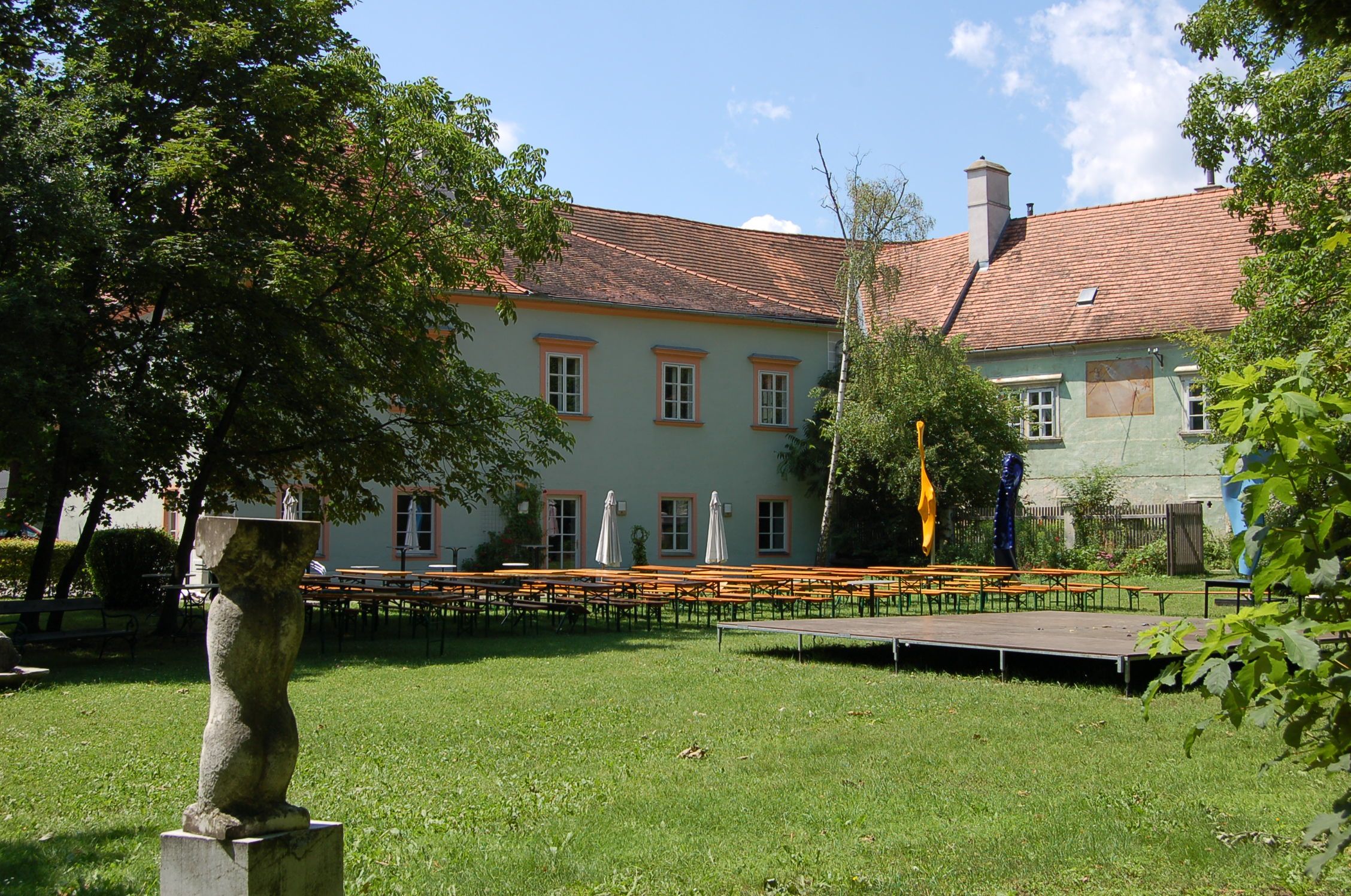 Bad Fischau Castle with garden and beer tables.