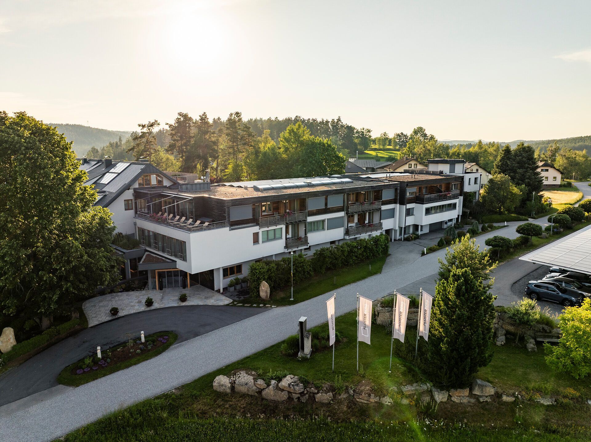 Exterior view of the Klosterberg Health Hotel in the Waldviertel region, surrounded by lush greenery and forests.