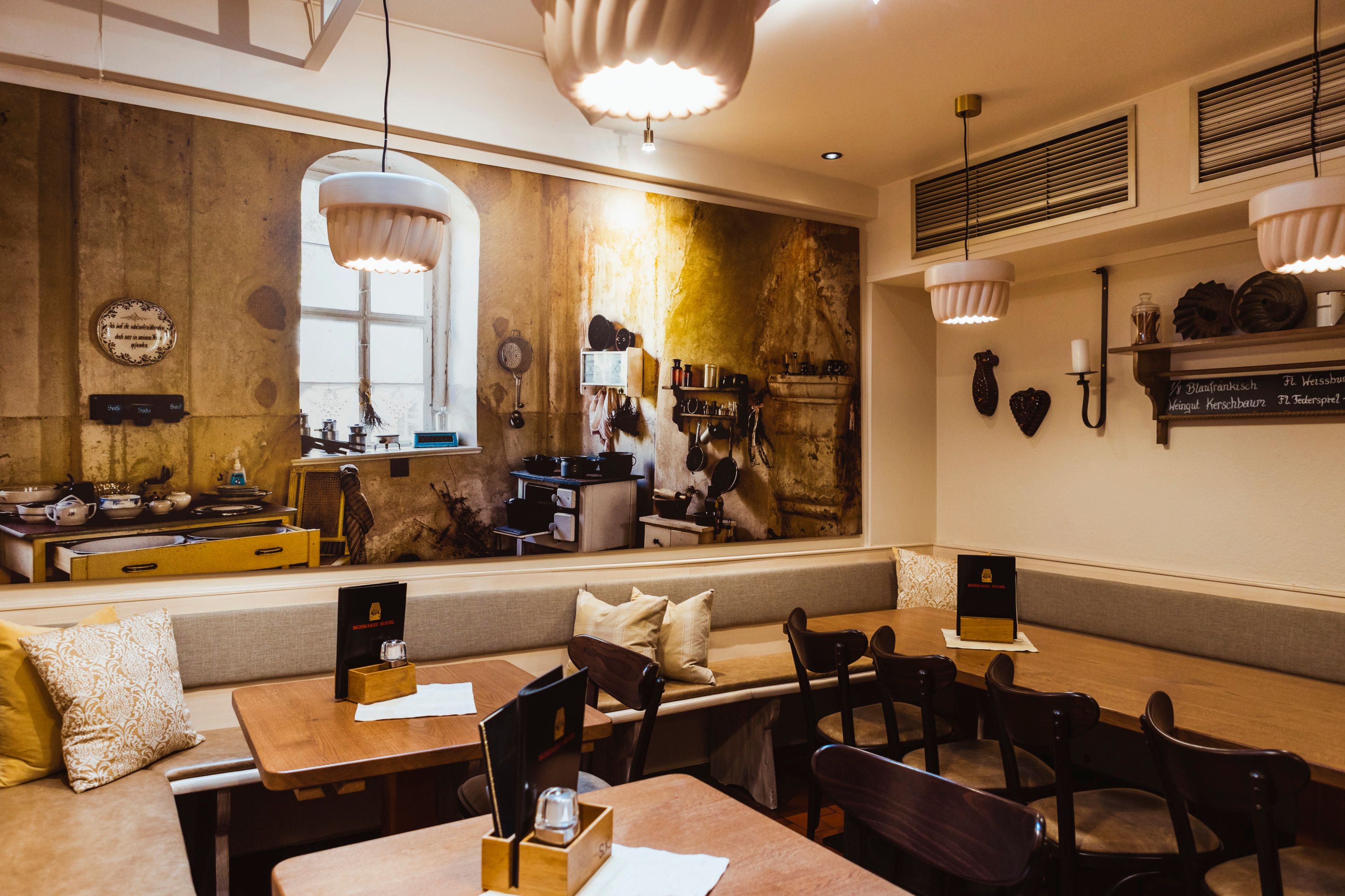 Cozy restaurant with a rustic mural of an old kitchen.