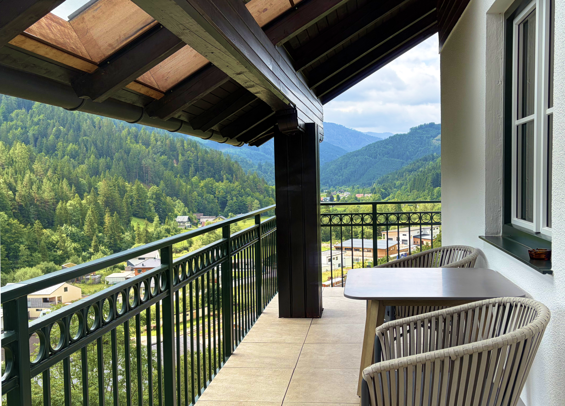Balcony with a table and chairs, overlooking Lunz am See.