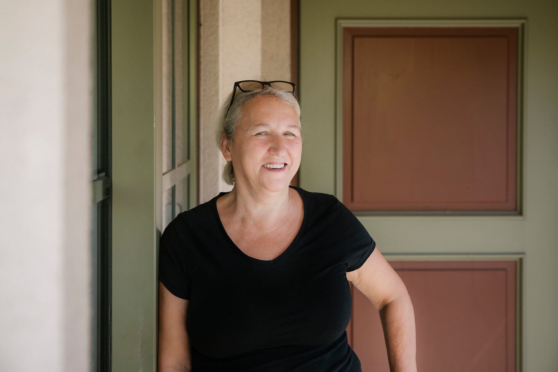 A smiling employee in front of the entrance to the Damböckhaus on Schneeberg