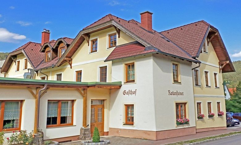 A traditional inn with several floors and red roof tiles.