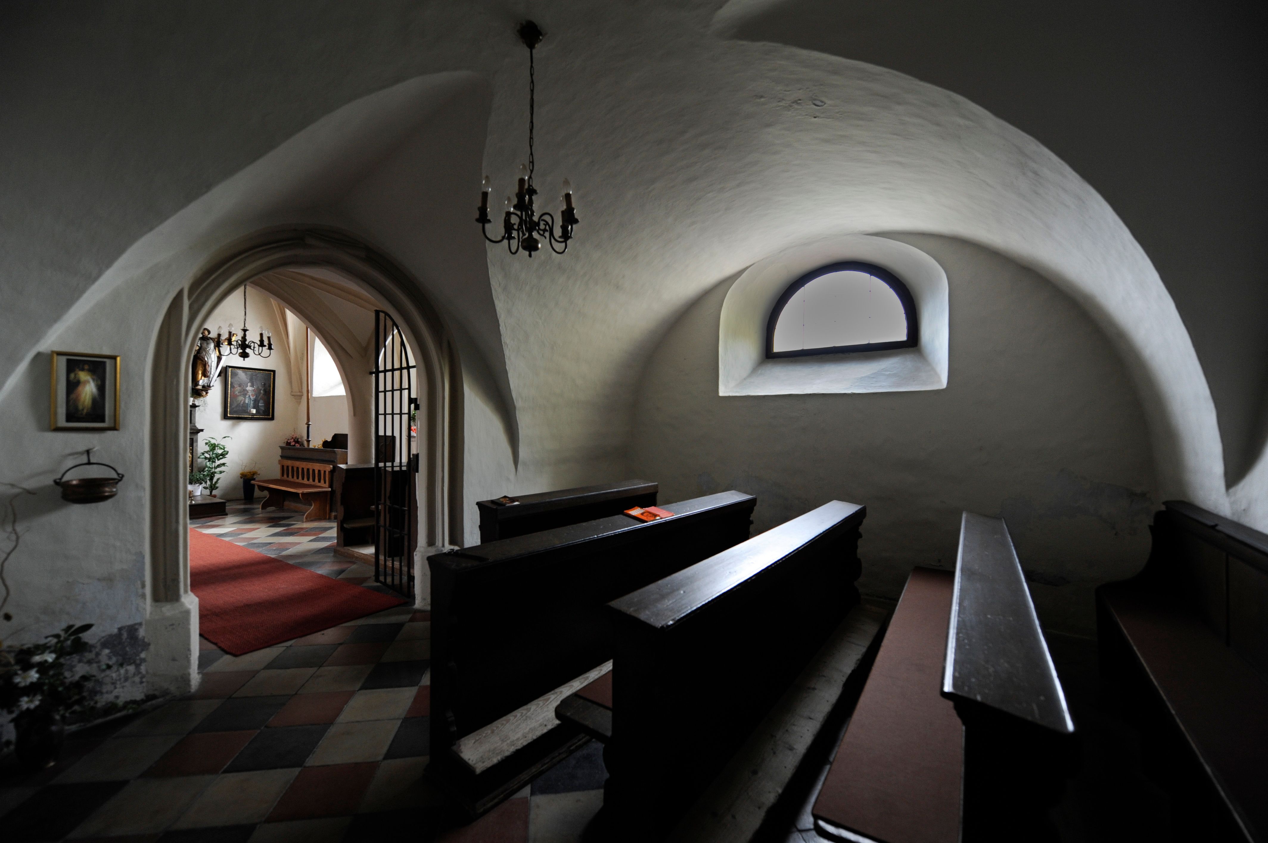 Interior of a church with vaulted ceiling and wooden benches