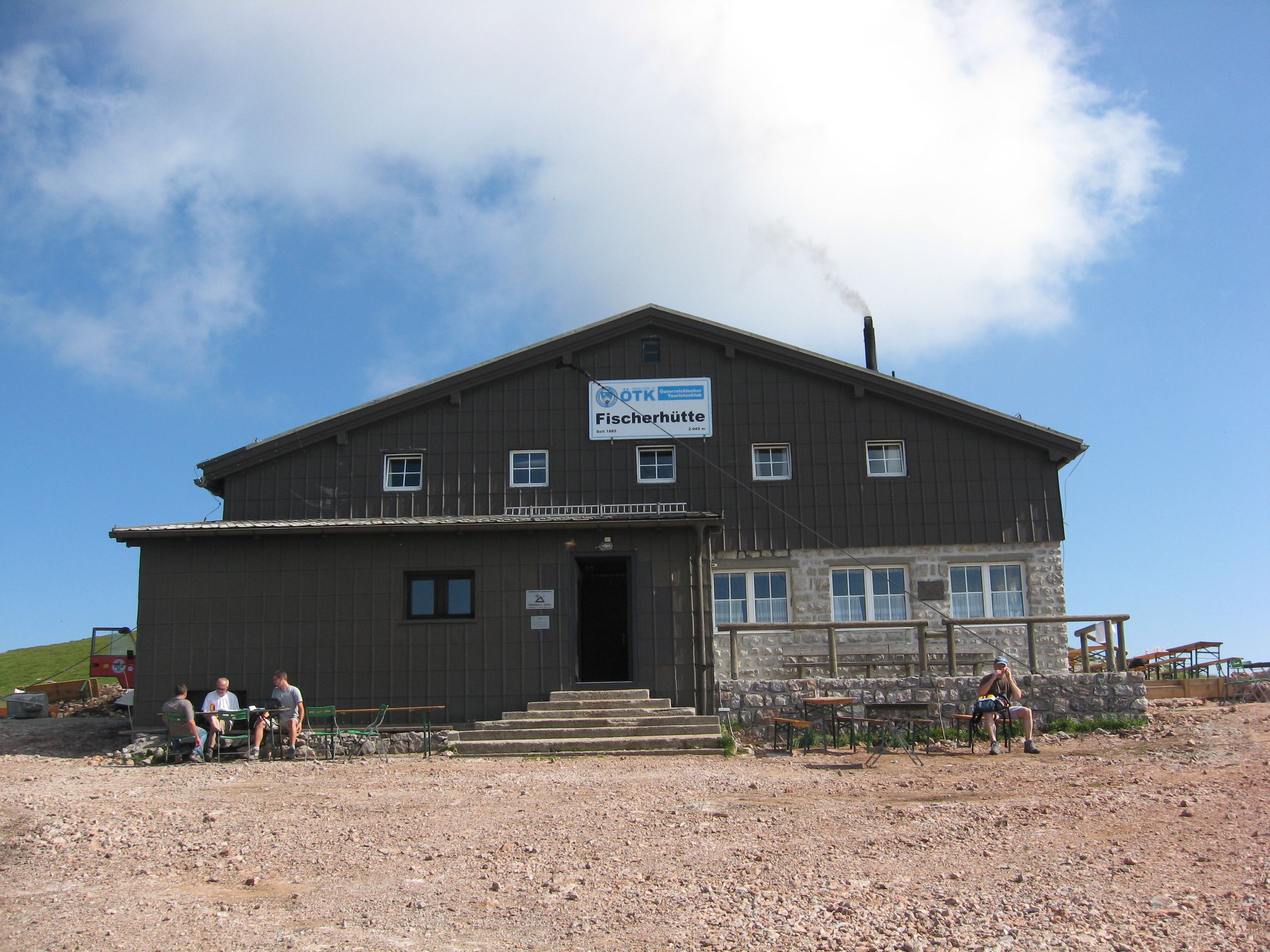 A large building with the inscription 'Fischerhütte' against a blue sky.