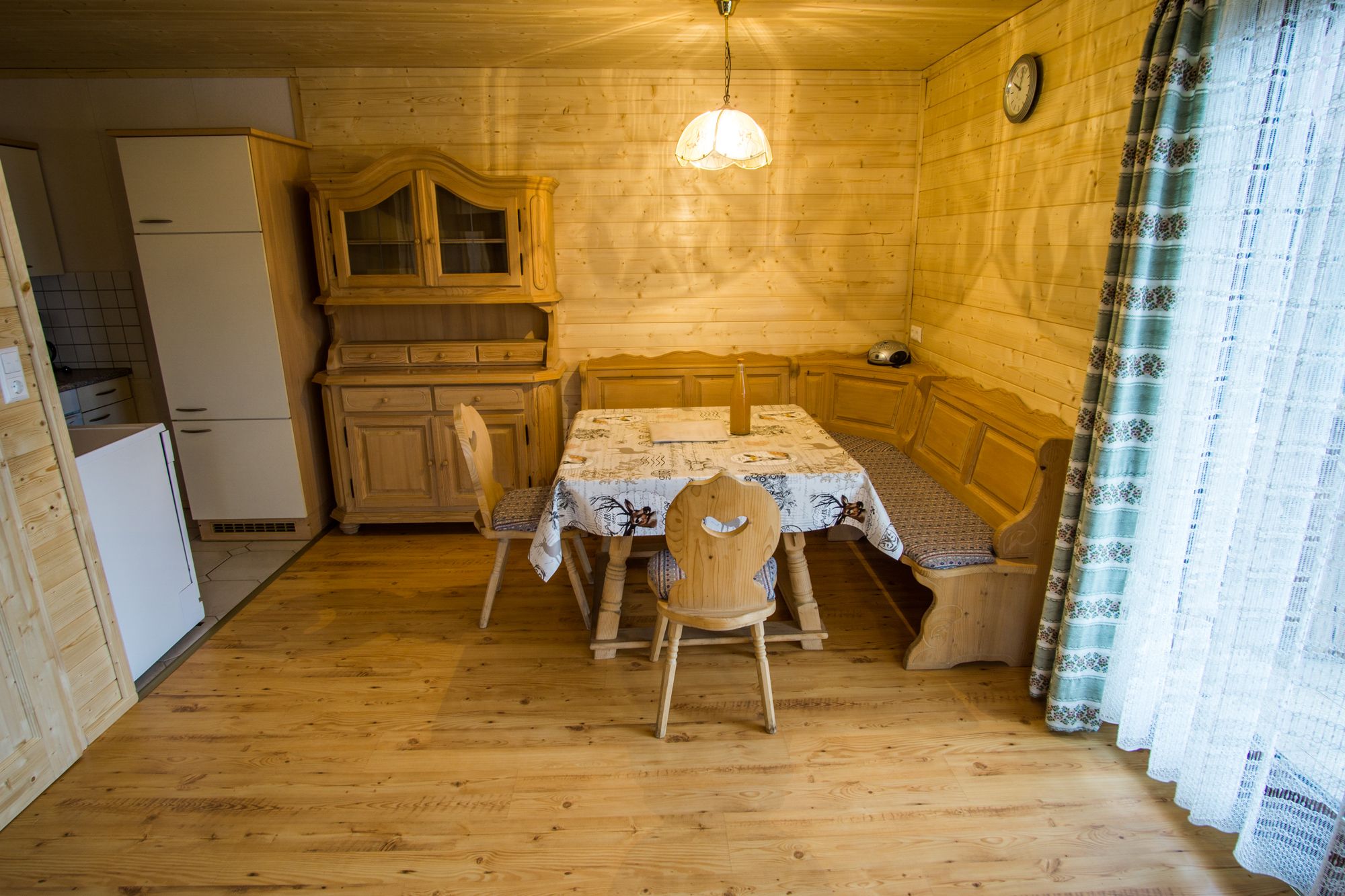 Dining area in a rustic vacation home with wooden furniture and corner bench.