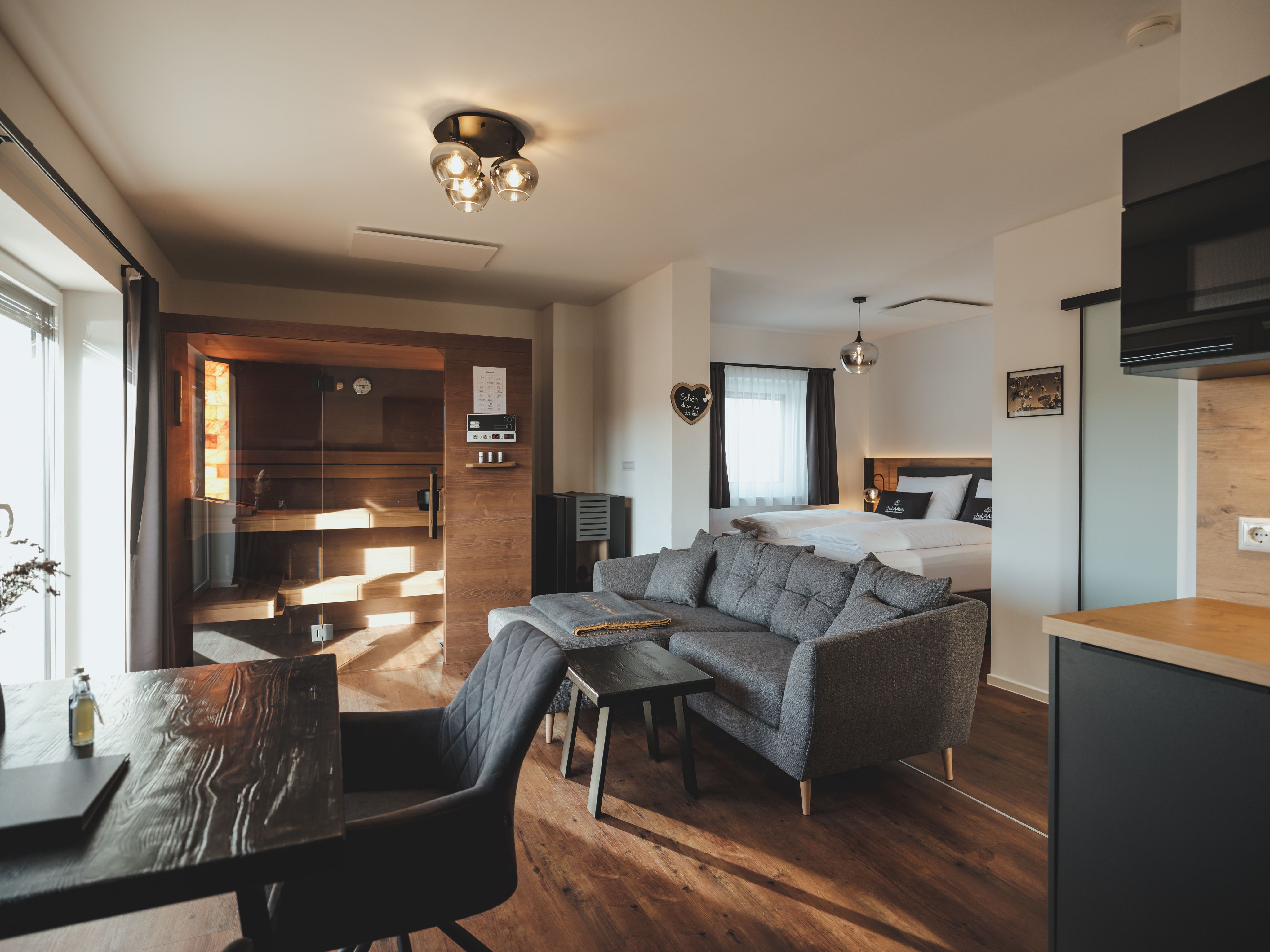 Interior view of a chalet with sauna, sofa and bed.
