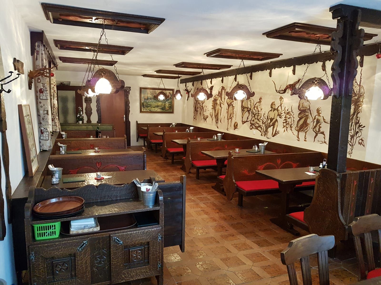 Interior view of a traditional Buschenschank (typical tavern) with wooden furniture and wall paintings.