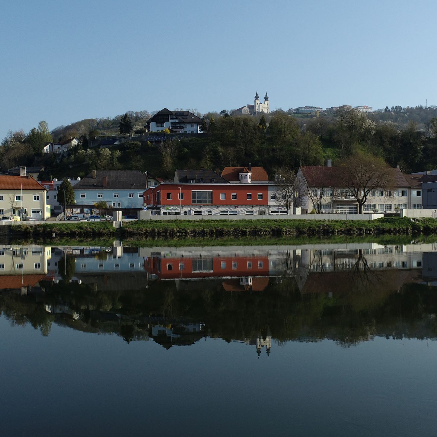Town view of Marbach with buildings and church reflected in the water.