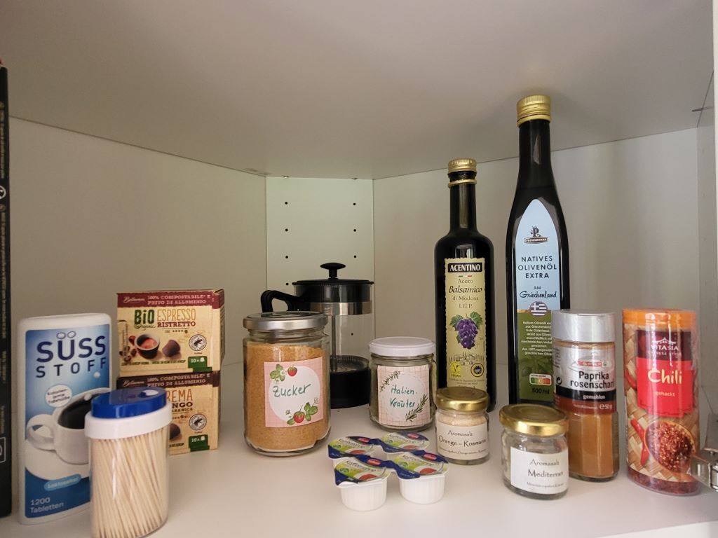 Storage cupboard with spices, oils and coffee.