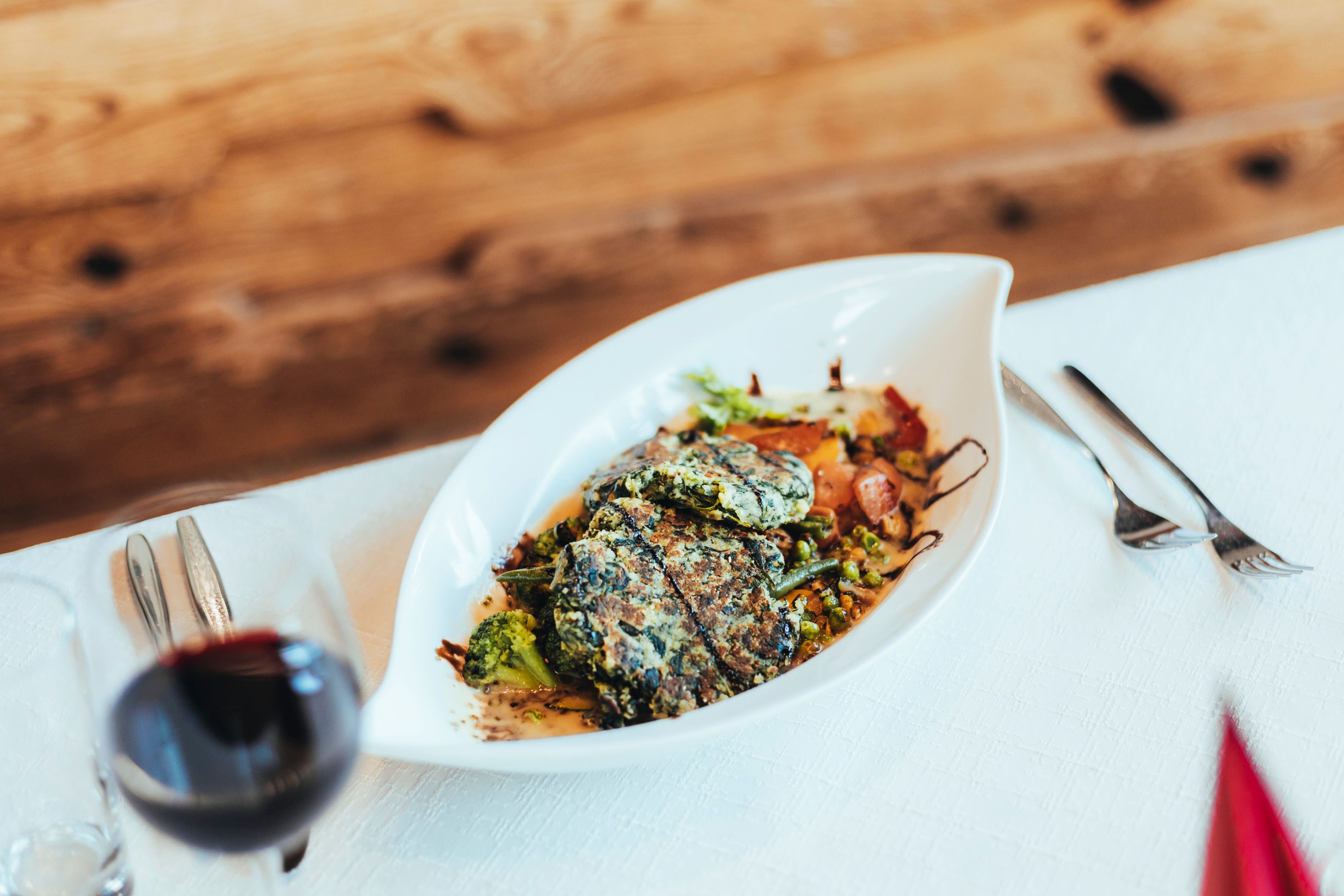 A plate of spinach loafs and vegetables on a table.