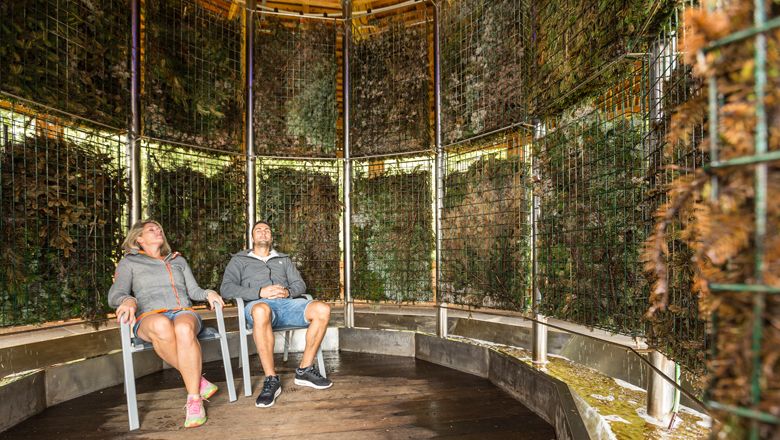 Two people sit relaxed in a graduation tower.