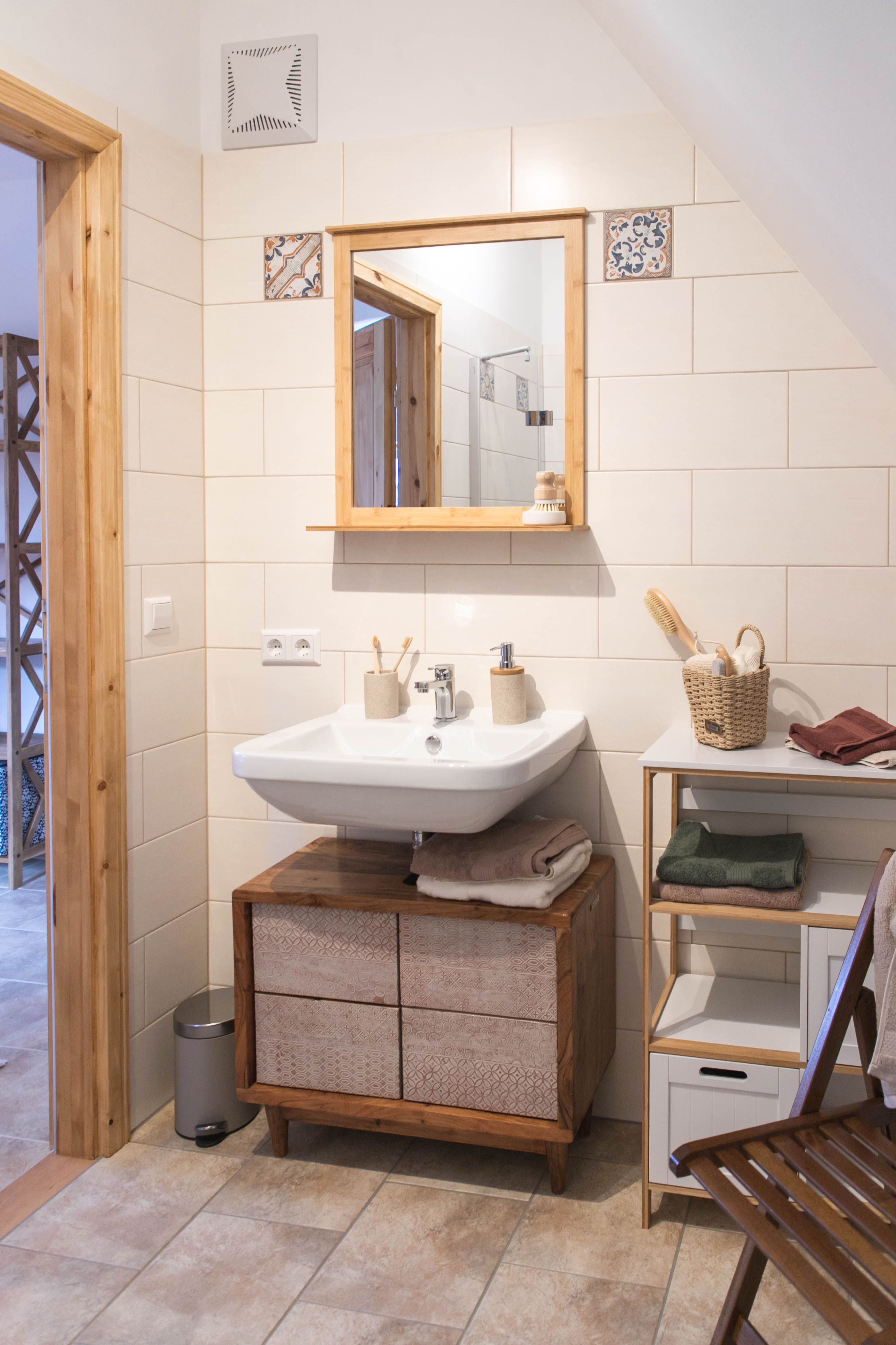 Modern bathroom with wooden details, washbasin, mirror and shelves.