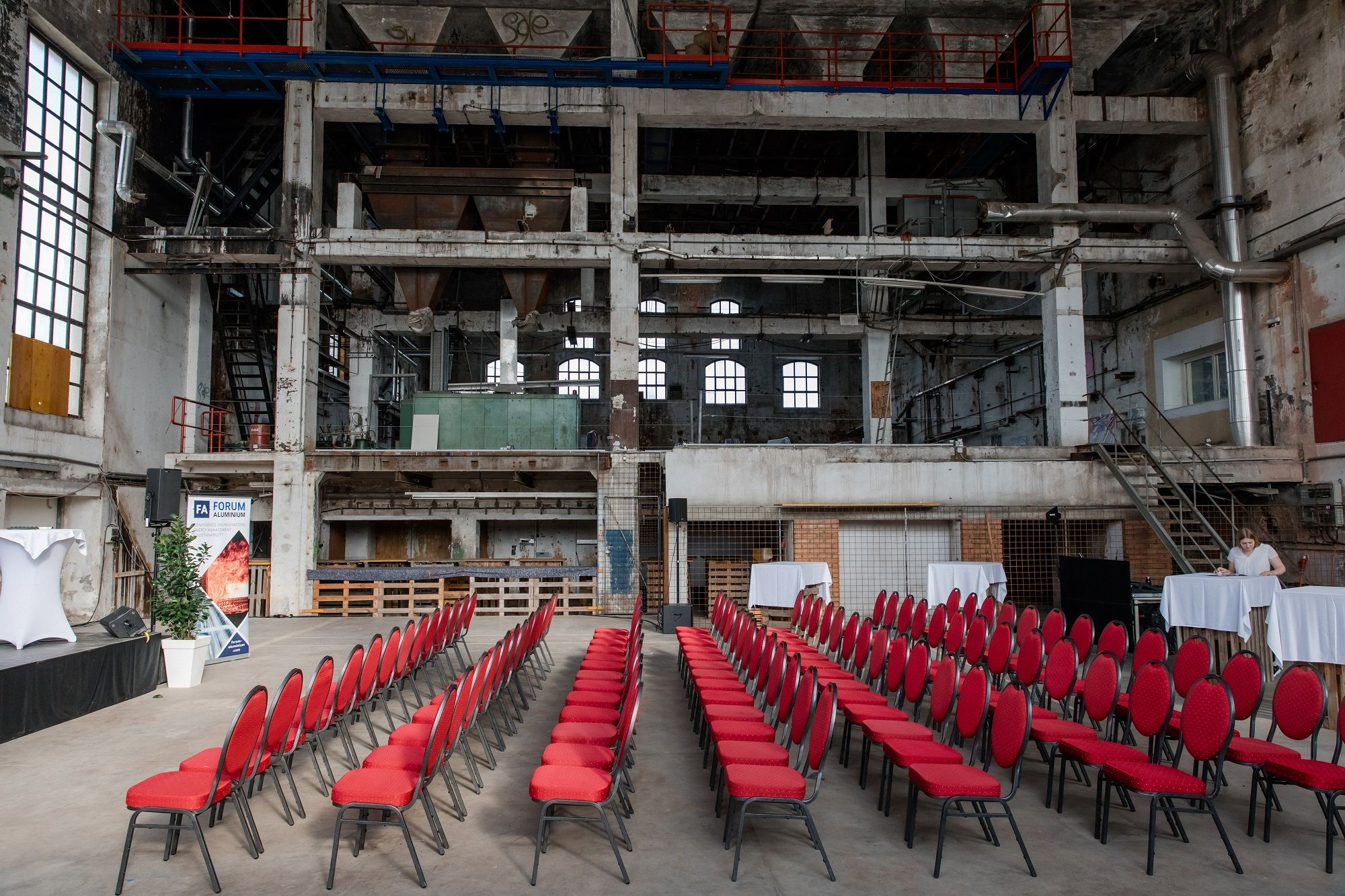 Interior view of an old boiler house with red chairs and event decorations.
