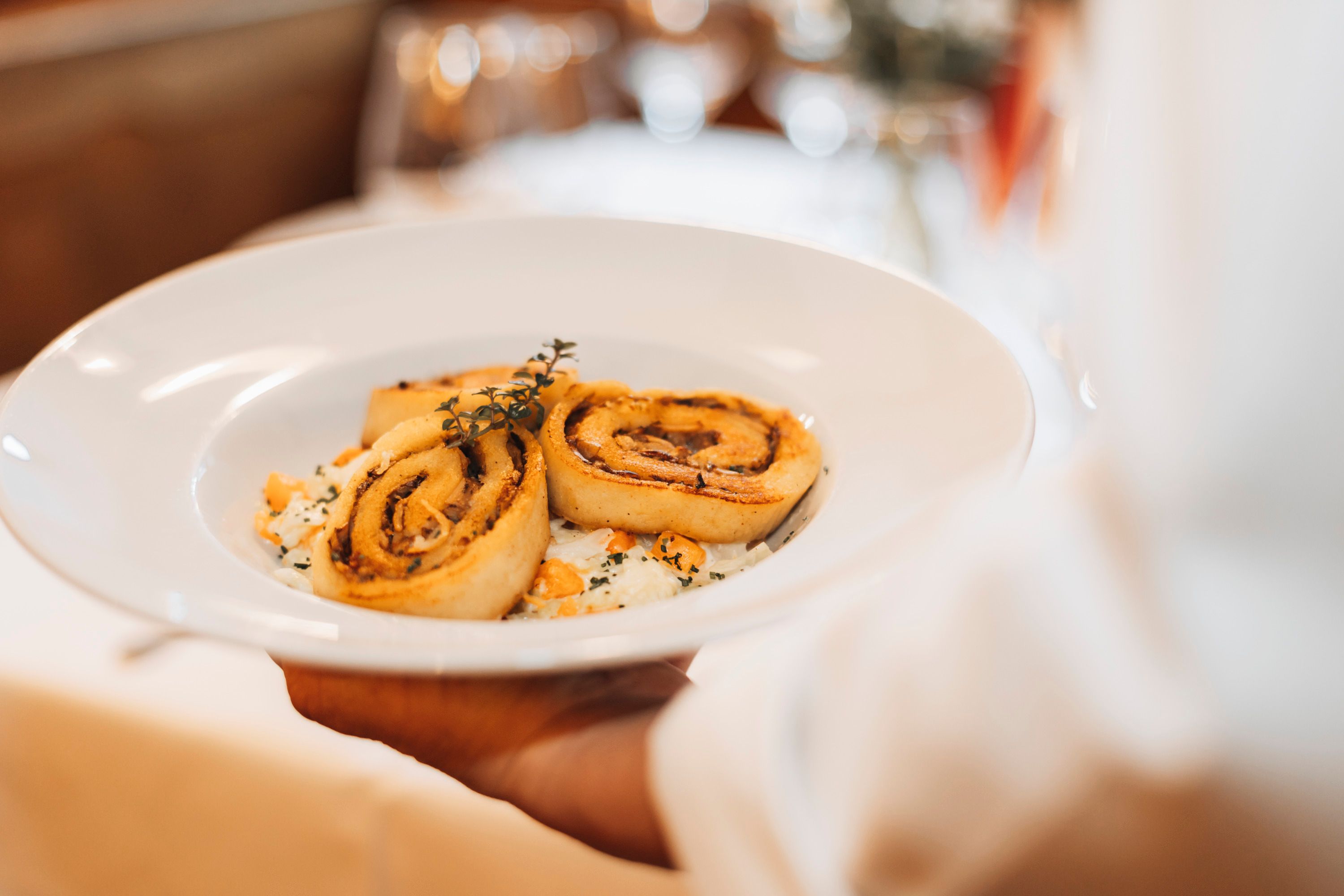 A plate of porcini mushroom roulades garnished with herbs is served.