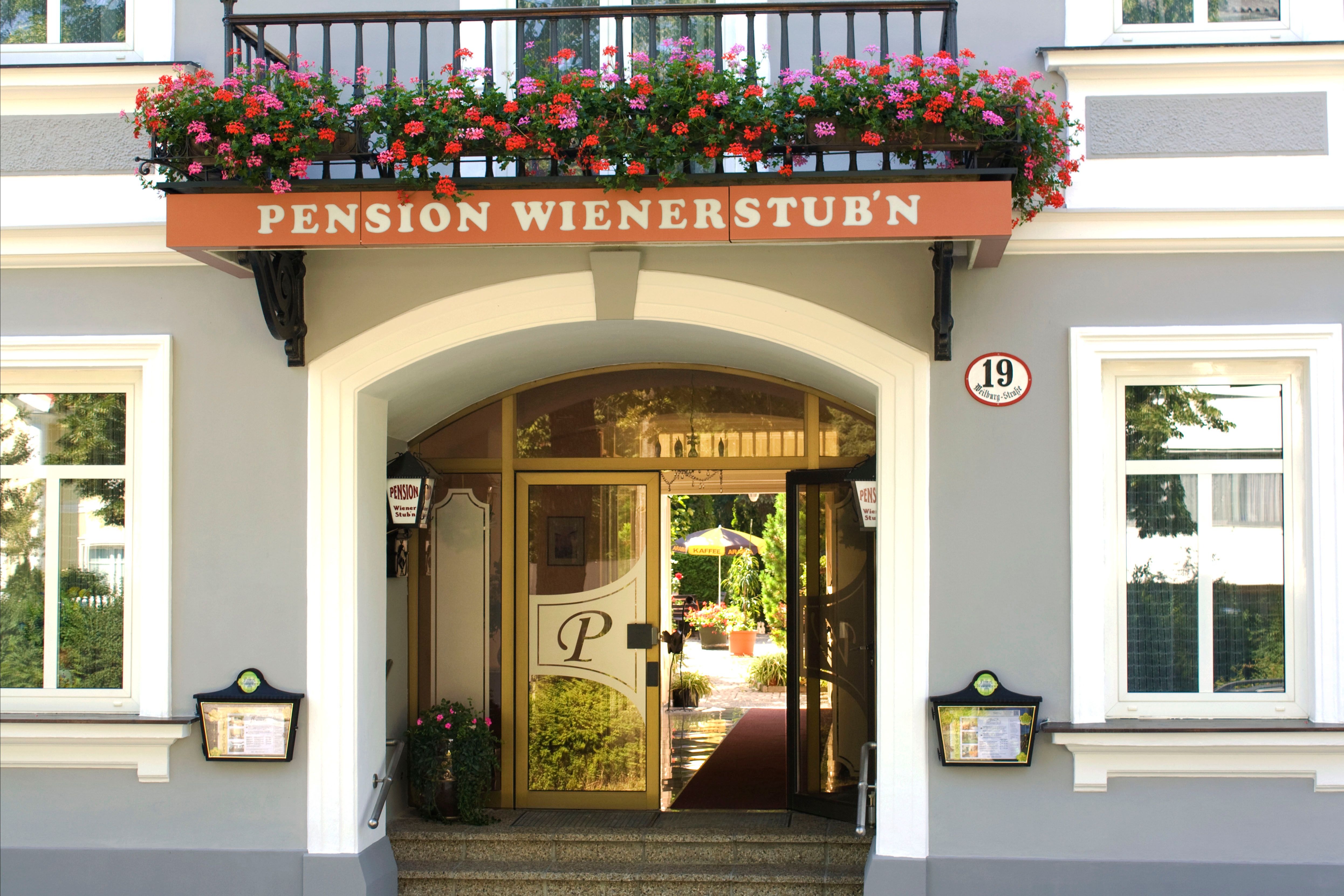 Entrance to the Pension Wienerstub'n with flowers and house number 19.
