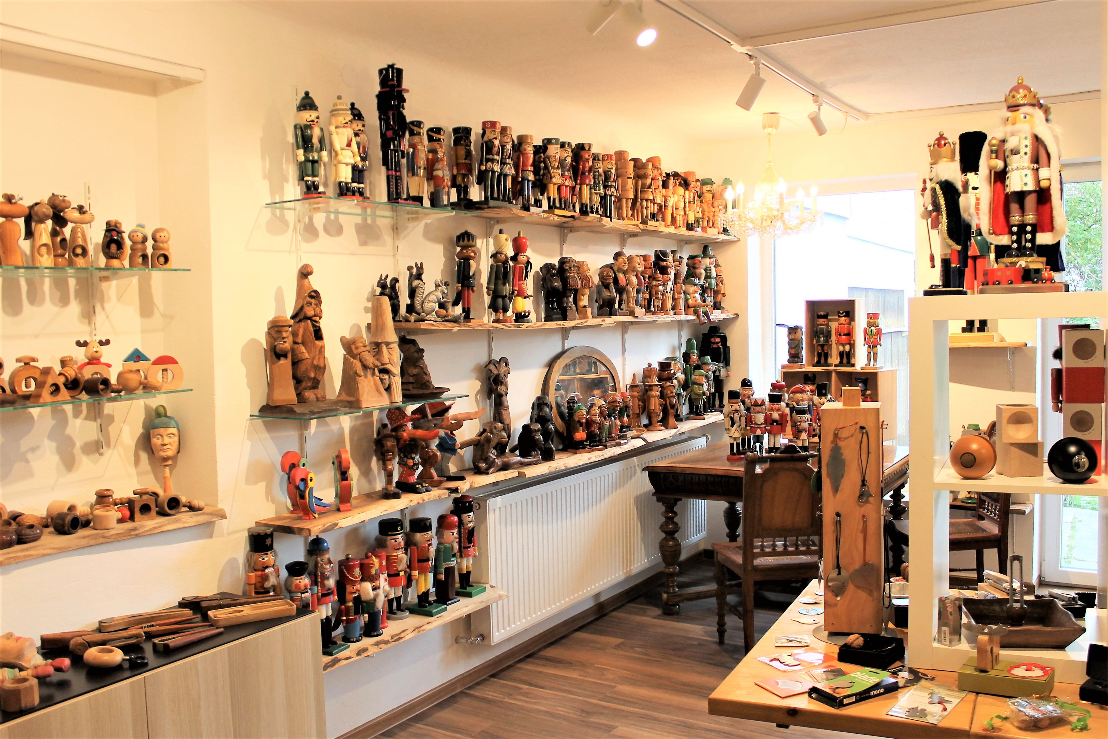A room full of nutcrackers and wooden figures on shelves and tables.