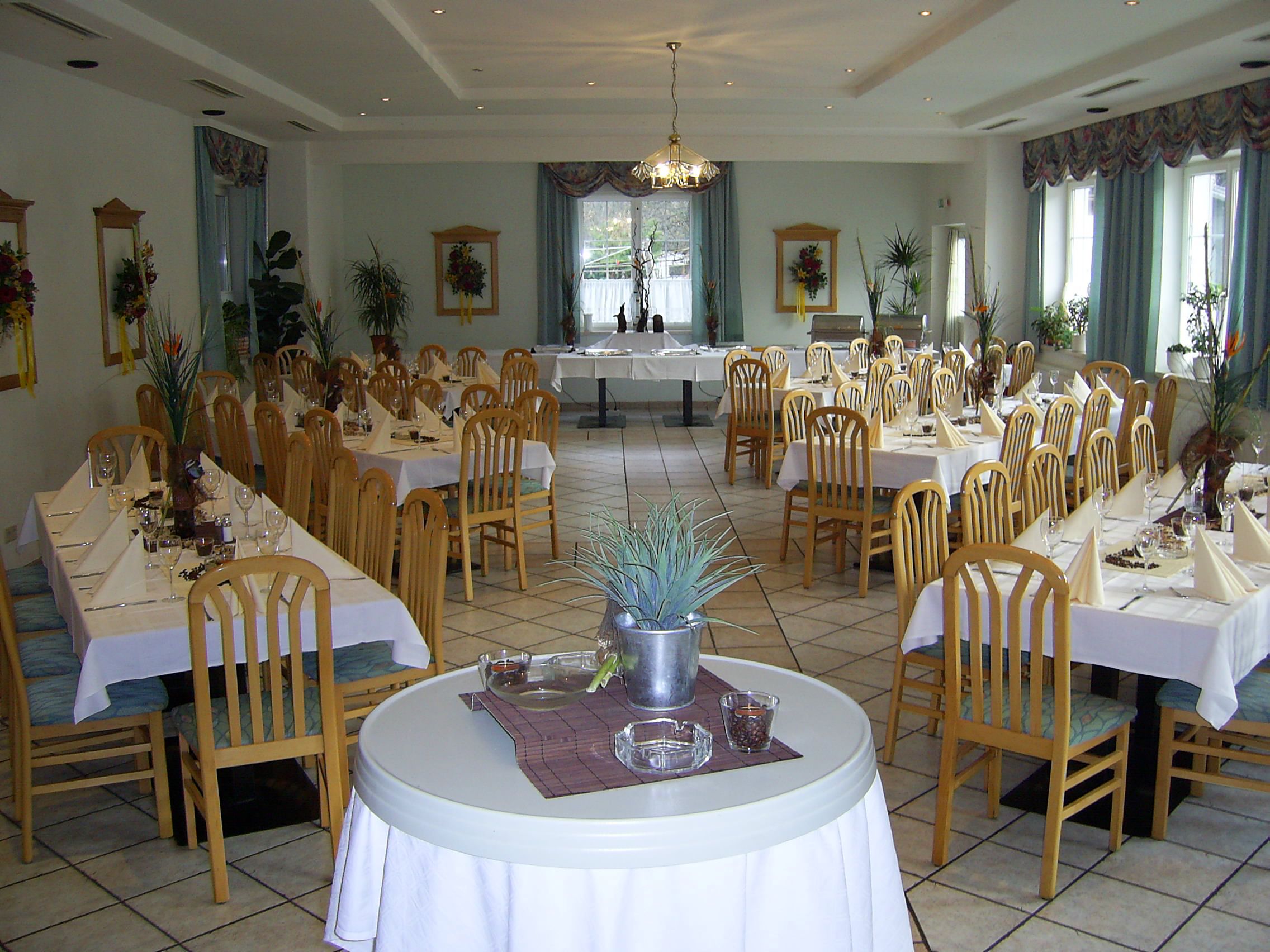 Elegant dining room with laid tables and wooden chairs.
