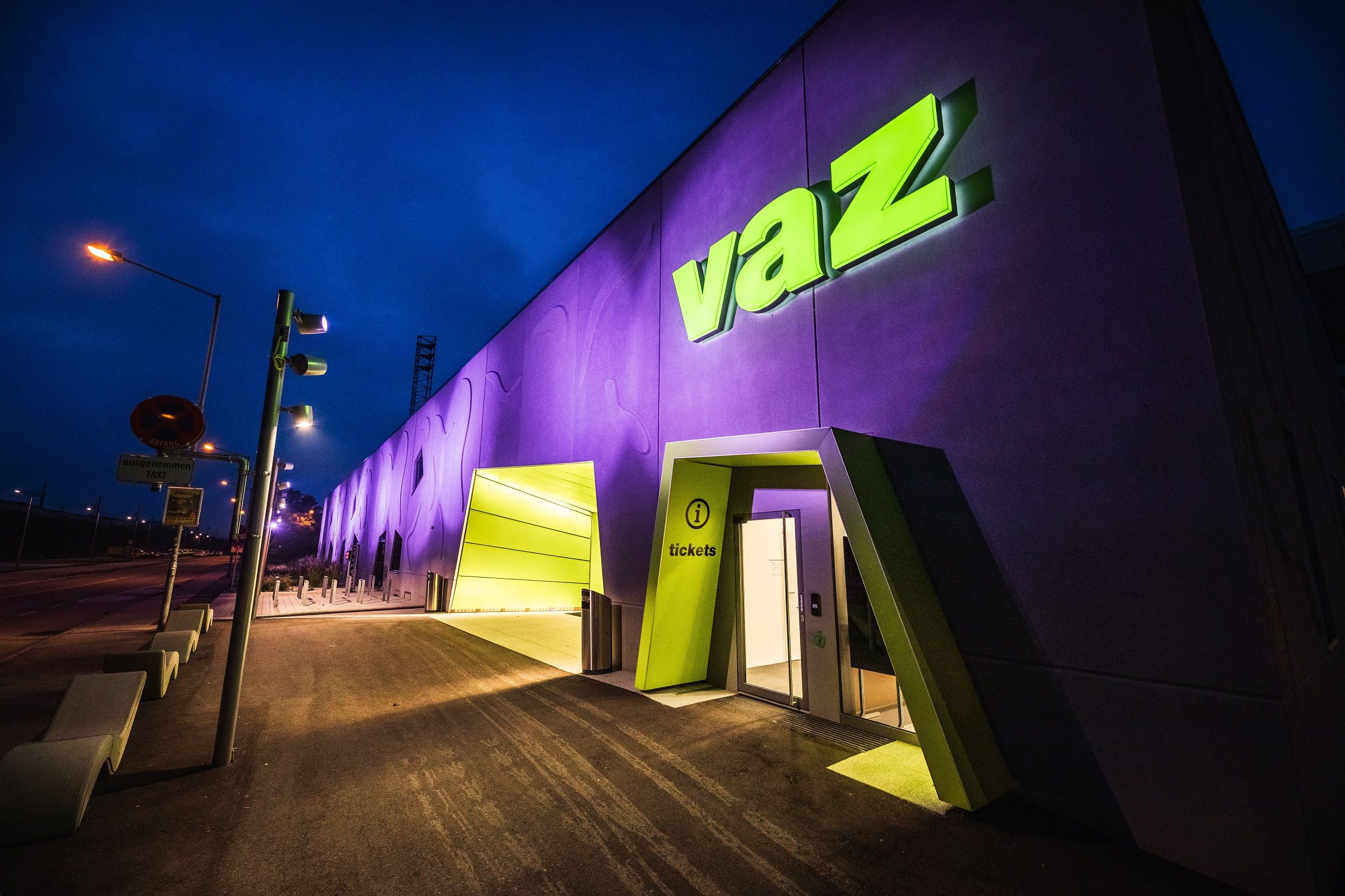 Entrance to the VAZ St. Pölten at night with illuminated sign.