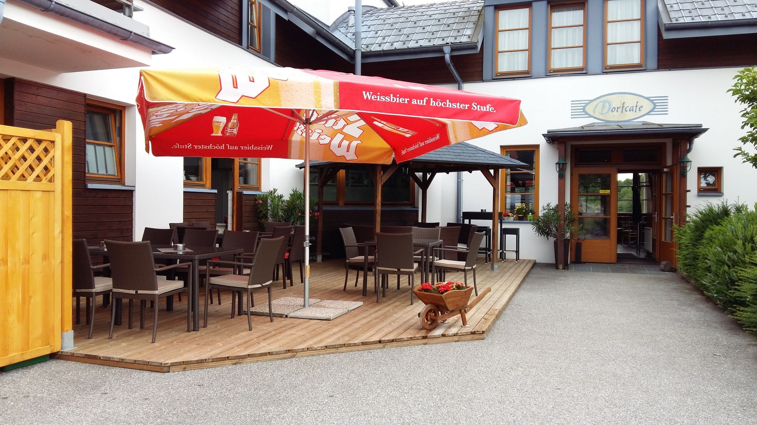 Outdoor area of a café with tables, chairs and parasols.