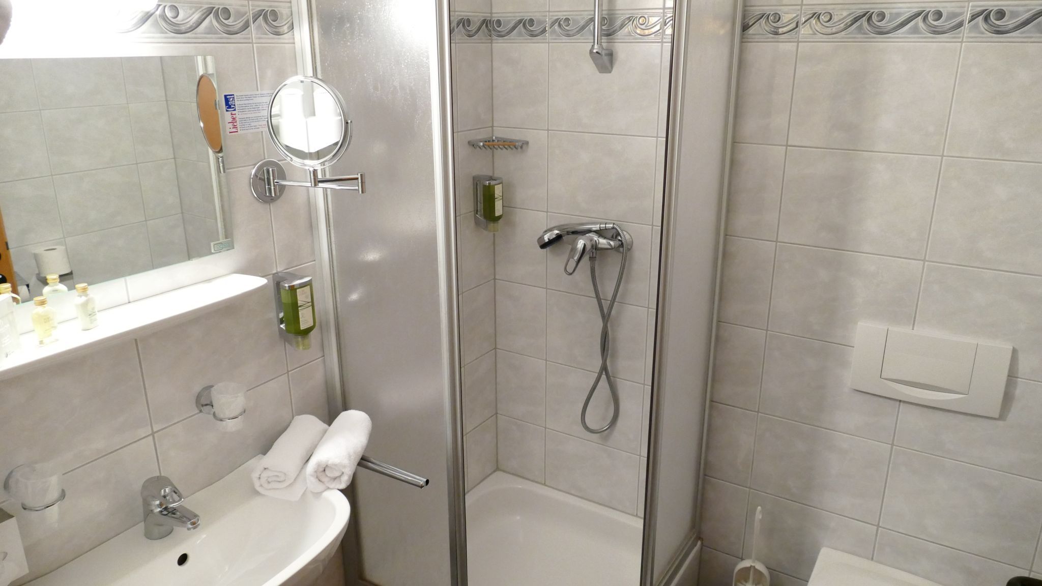 Bathroom with shower, washbasin and mirror.