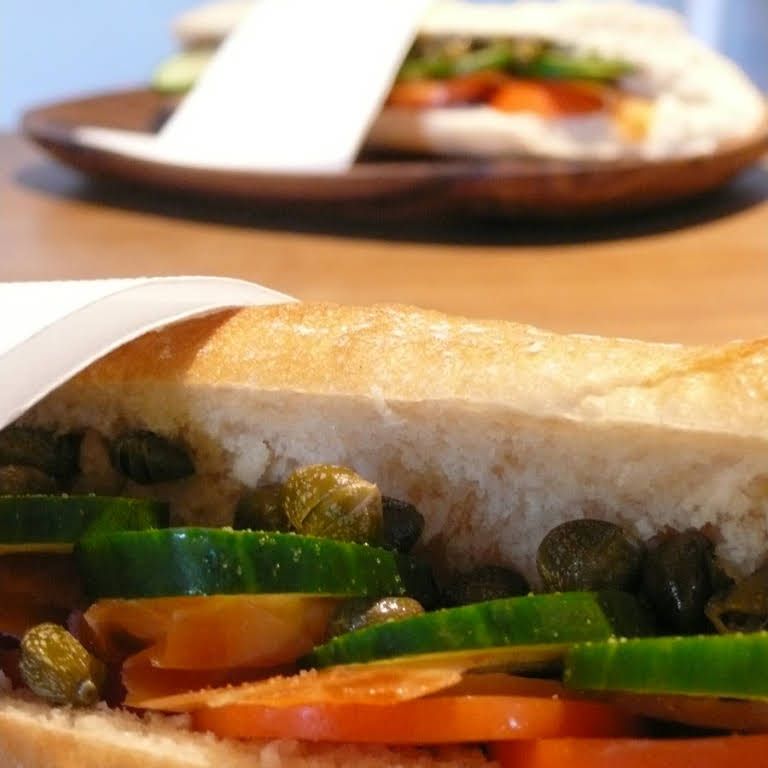 Close-up of a sandwich with cucumber, tomatoes and capers.
