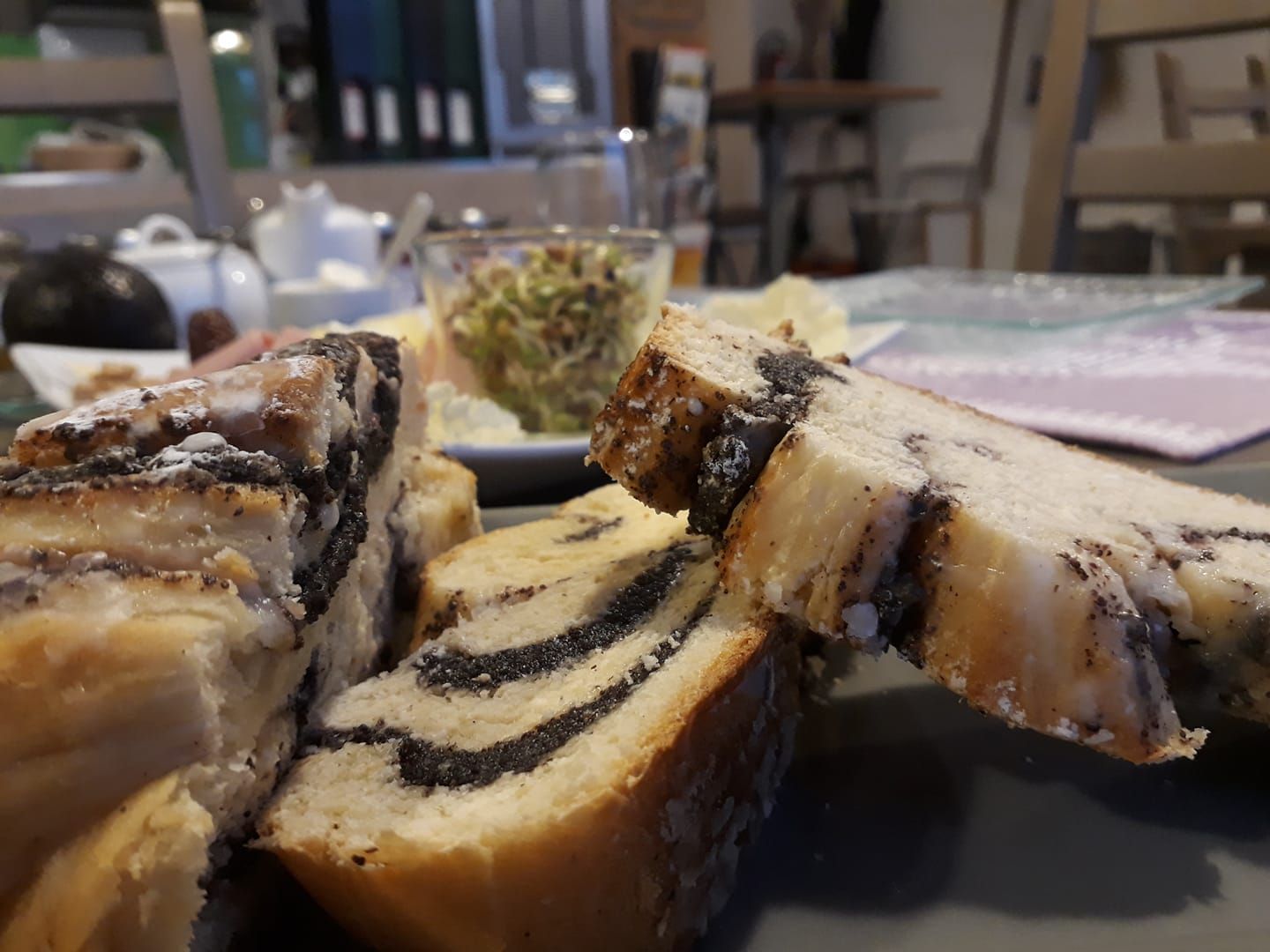 Close-up of poppy seed cake on a breakfast table with blurred background.