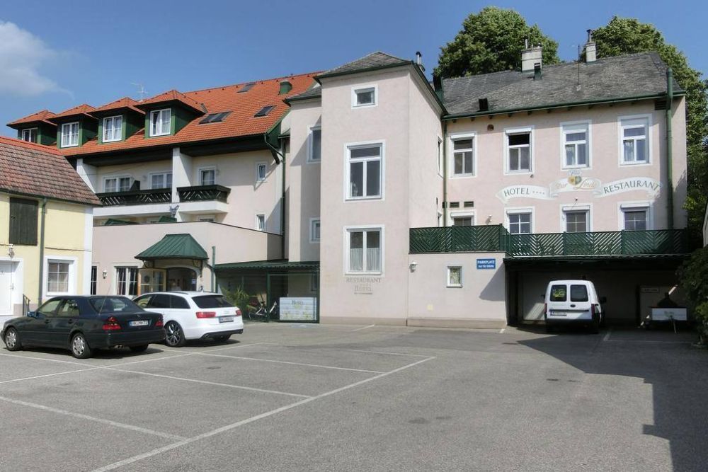 Exterior view of a hotel with parking lot and cars.