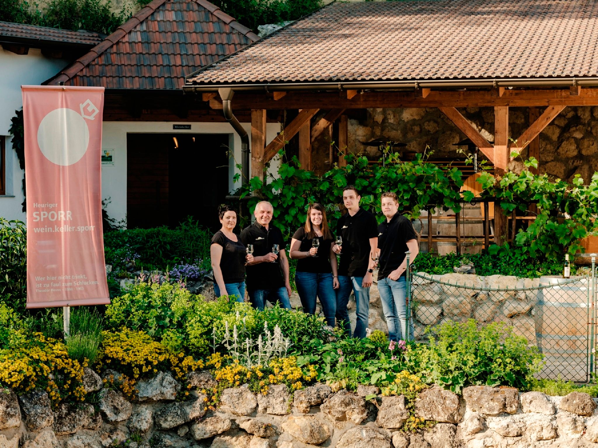Group of five people in front of a winery with a Sporr banner.