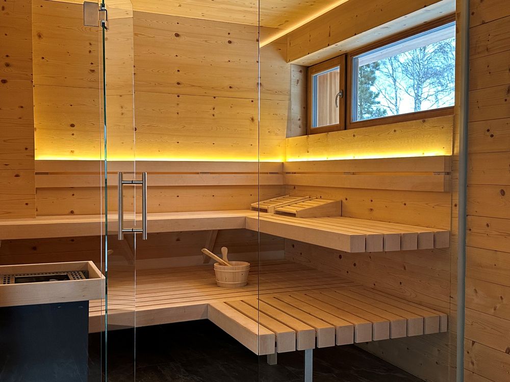 Interior view of a modern sauna with wooden benches and glass wall.