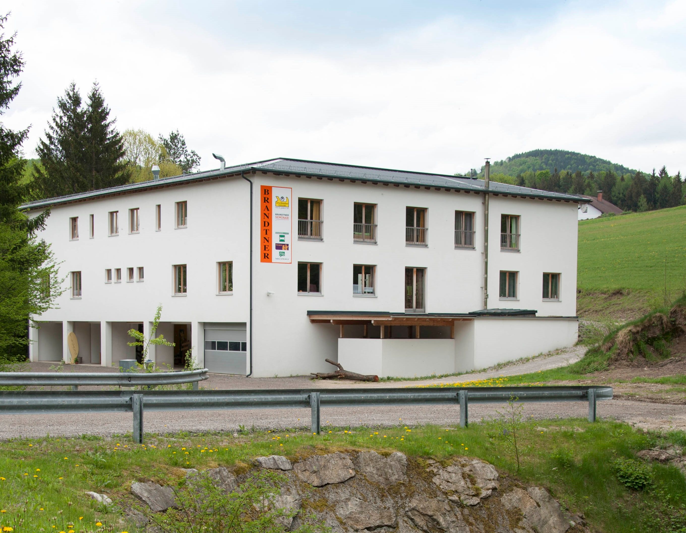 A white building with the inscription 'Brandtner' in a rural setting.