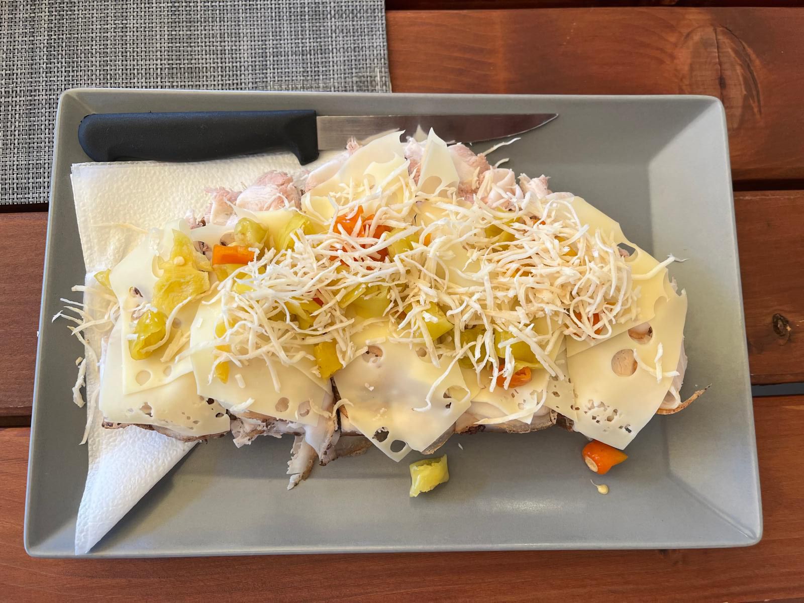 A cheese sandwich with vegetables and grated horseradish on a gray plate.