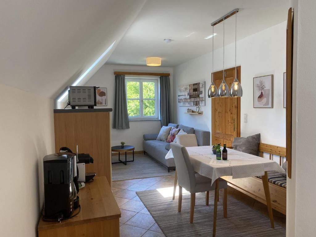 Cozy living room with dining table, sofa and kitchenette in a country house style.