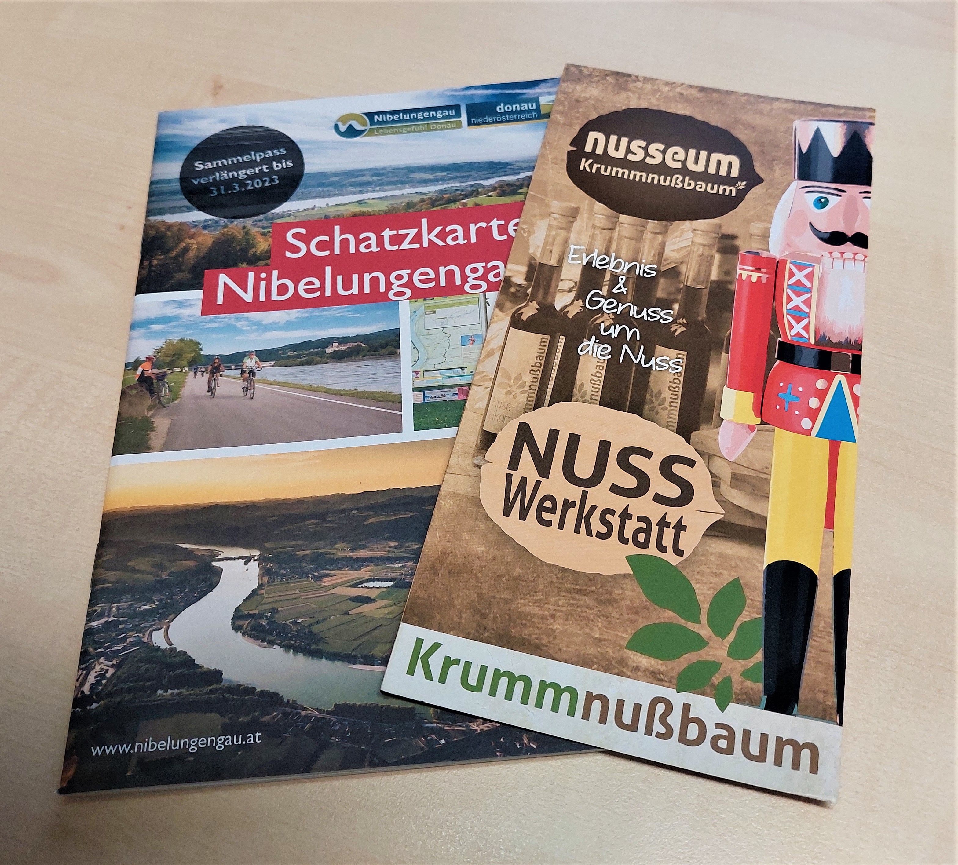 Two brochures on a table: one about the Nibelungengau treasure map and one about the Nusseum Krummnußbaum.