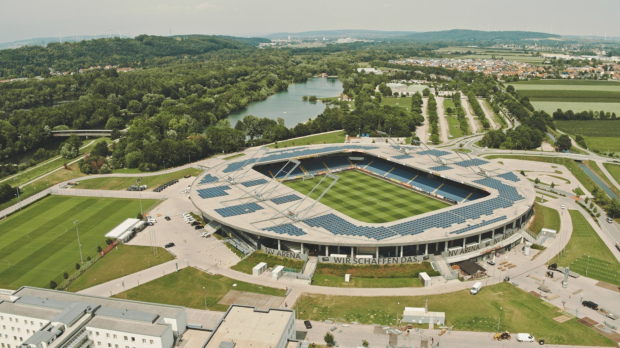 Aerial view of the NV Arena in St. Pölten, surrounded by green countryside and a river.