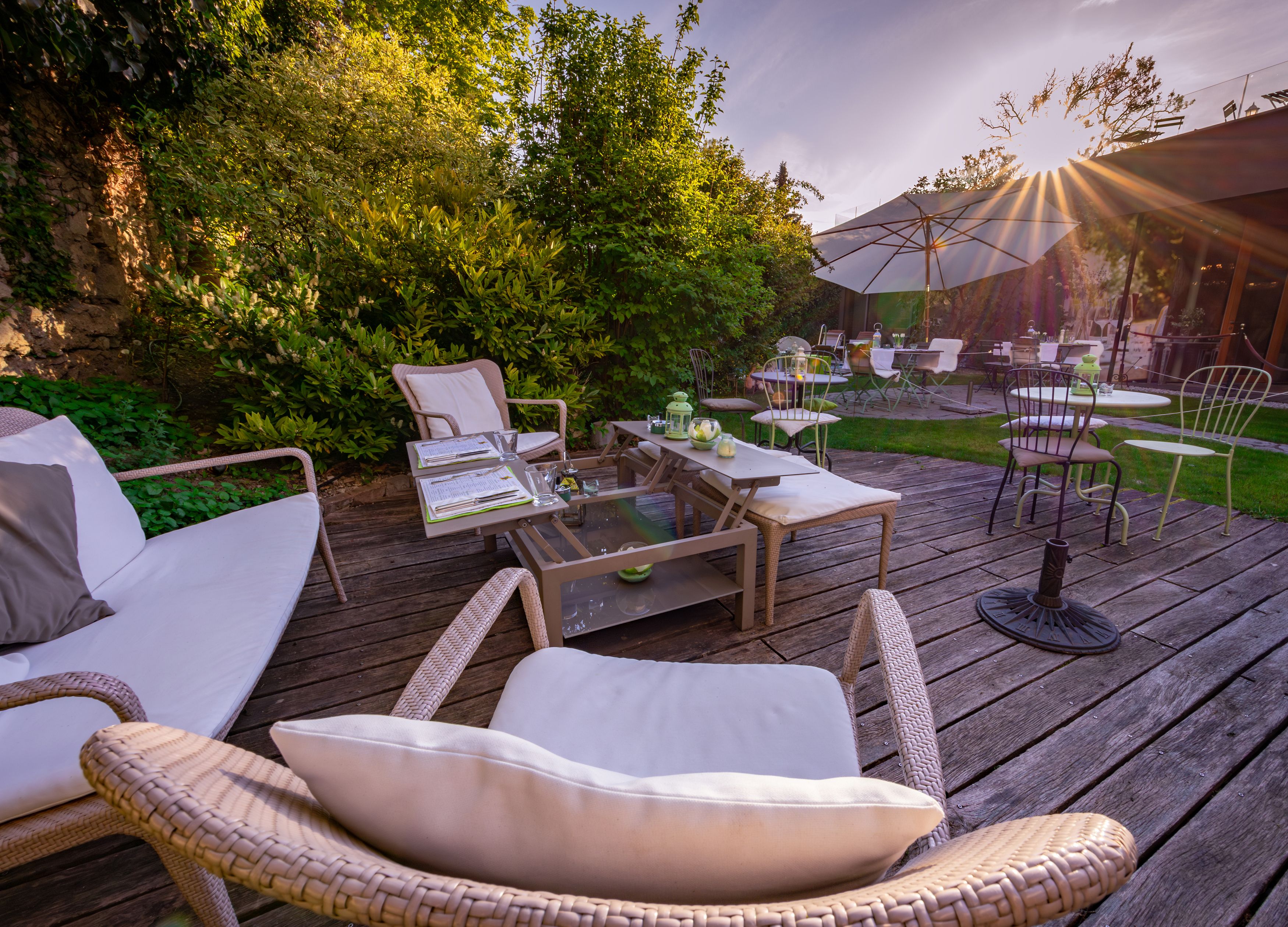 Comfortable terrace with seating furniture and parasols in the garden of a hotel.
